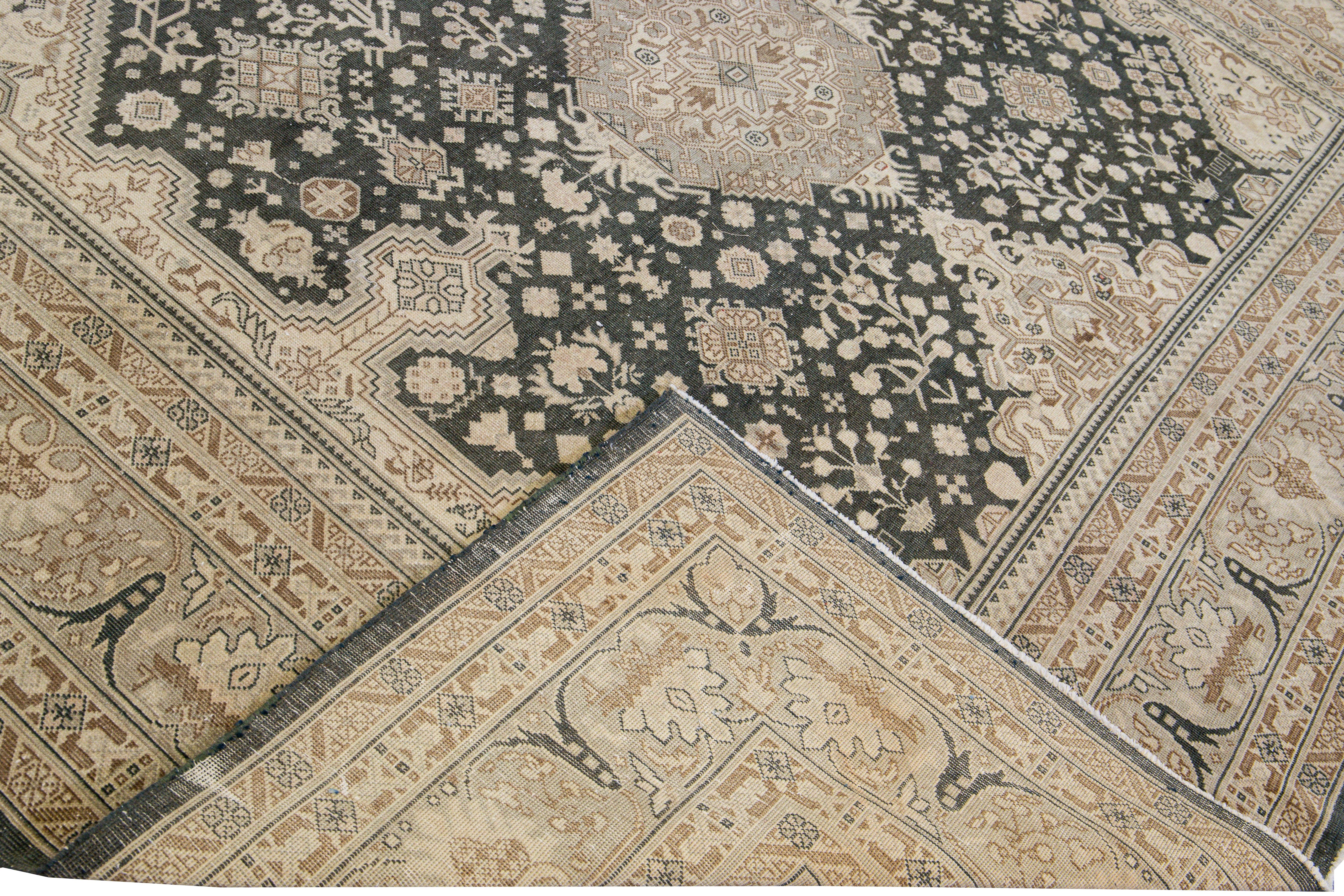 Wunderschöner antiker Tabriz-Teppich aus handgeknüpfter Wolle mit einem dunkelgrauen und beigen Feld. Dieser Perserteppich hat einen beigefarbenen Rahmen und braune Akzente in einem prächtigen Stammesmedaillon-Motiv.

Dieser Teppich misst: 9'1