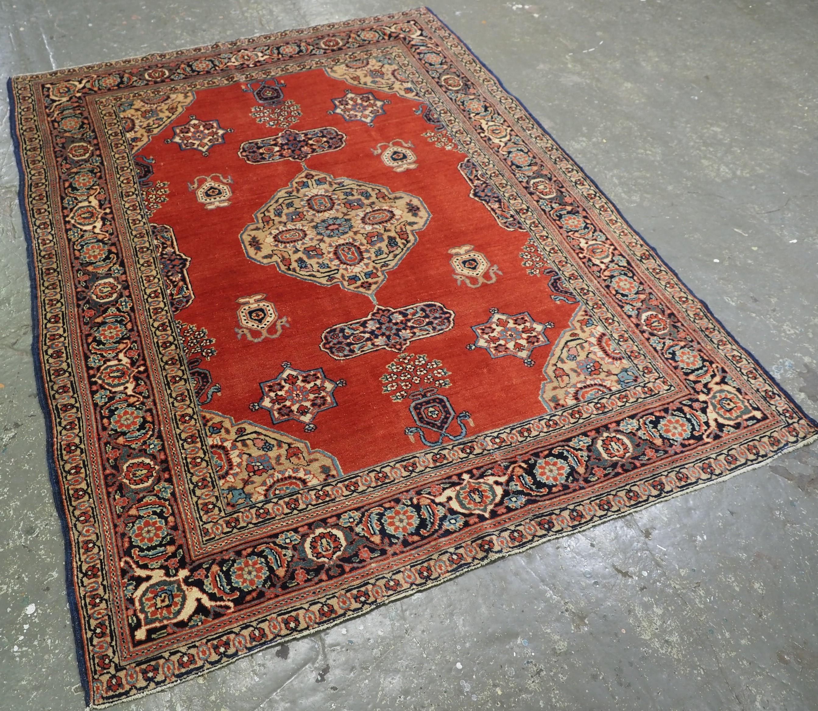 
Size: 6ft 0in x 4ft 8in (182 x 141cm).

Antique Tabriz region village rug of outstanding design with a small central medallion on a madder red ground.

Circa 1900.

The rug has a classical small medallion design with floral vases at each end, the