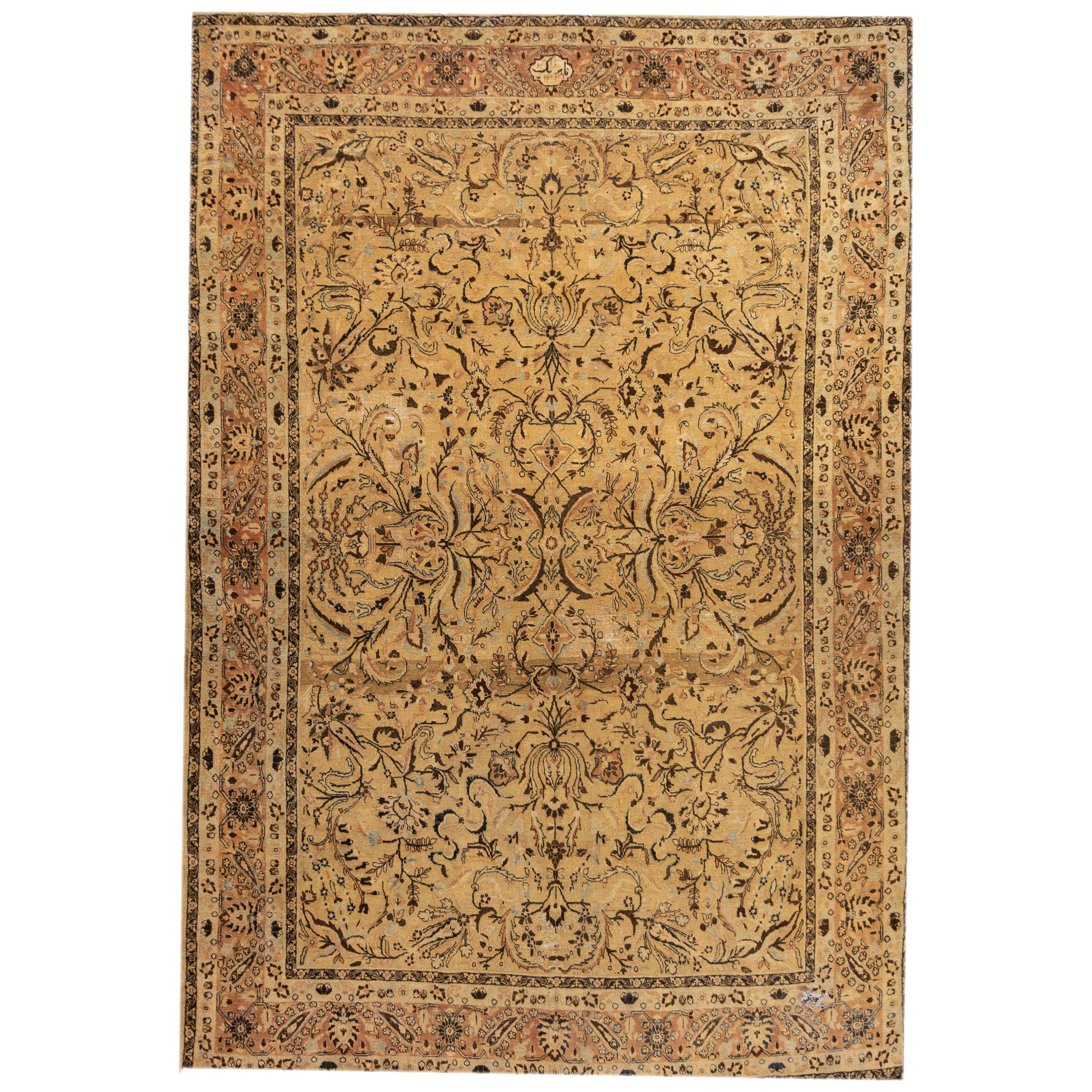 An early 20th century antique Tabriz rug with an all over beige and brown motif. This rug measures 10'4
