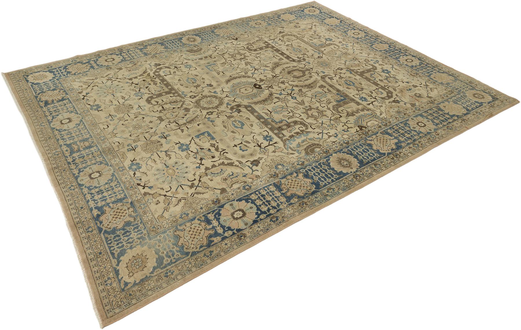 Hand knotted Persian Tabriz rug, woven in Iran circa 1930.

This elegant antique Tabriz features an intricate allover floral and arabesque design in soft beige, taupe and blue tones. The refined motifs and symmetrical composition exemplify the