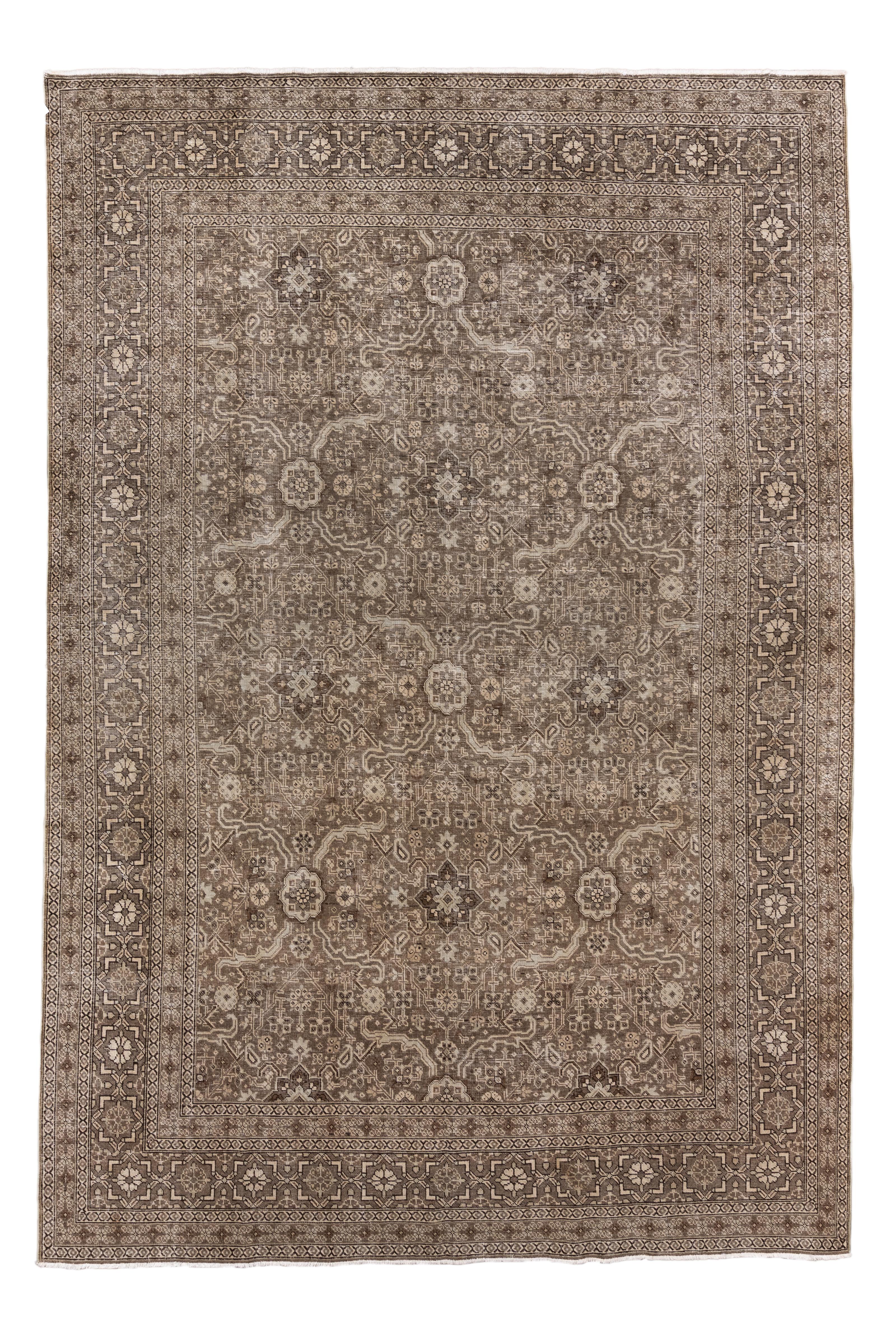 This stunning antique Tabriz rug offers an exquisite example of Persian city weaving, characterized by its sophisticated allover design and neutral, elegant palette. Woven in tones of taupe, mocha, ivory, and faded chocolate, the intricate field
