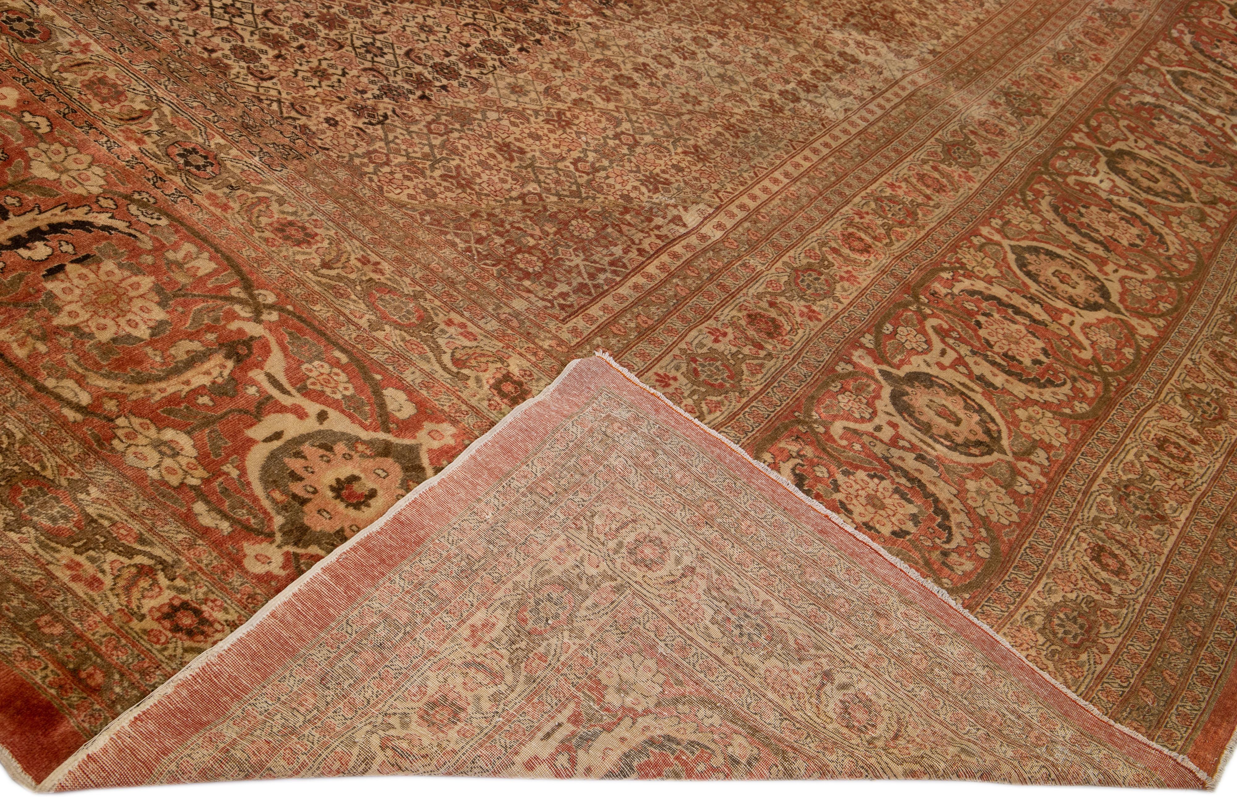 Magnifique tapis antique Tabriz en laine nouée à la main avec un champ de couleur rouille. Cette pièce persane a un accent brun dans un magnifique motif floral. 

Ce tapis mesure : 17'8