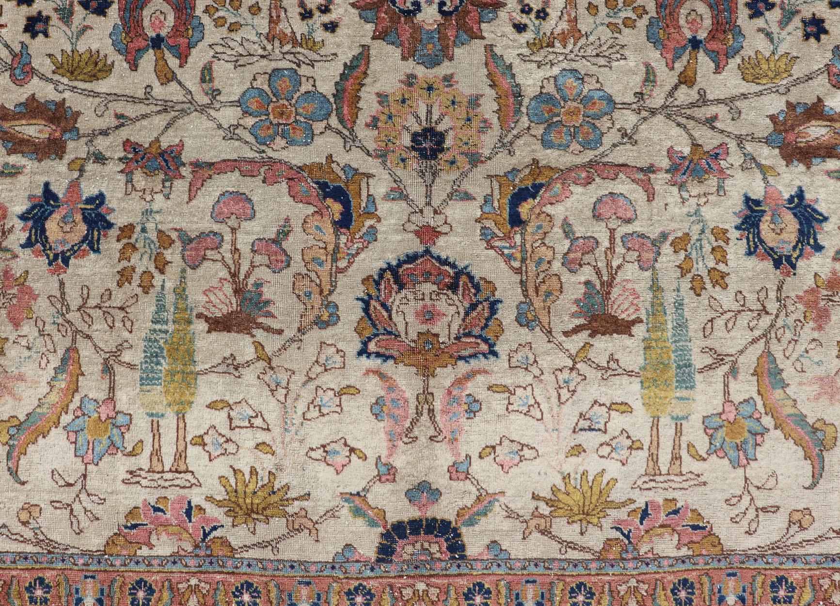 Questo splendido tappeto Tabriz antico (circa 1920) presenta un delizioso disegno floreale all-over in oro, corallo, blu e rosa su uno sfondo avorio. Un bordo complementare circonda l'intero pezzo con uno sfondo blu navy. 

Misure: 7'9'' x 11'0''.