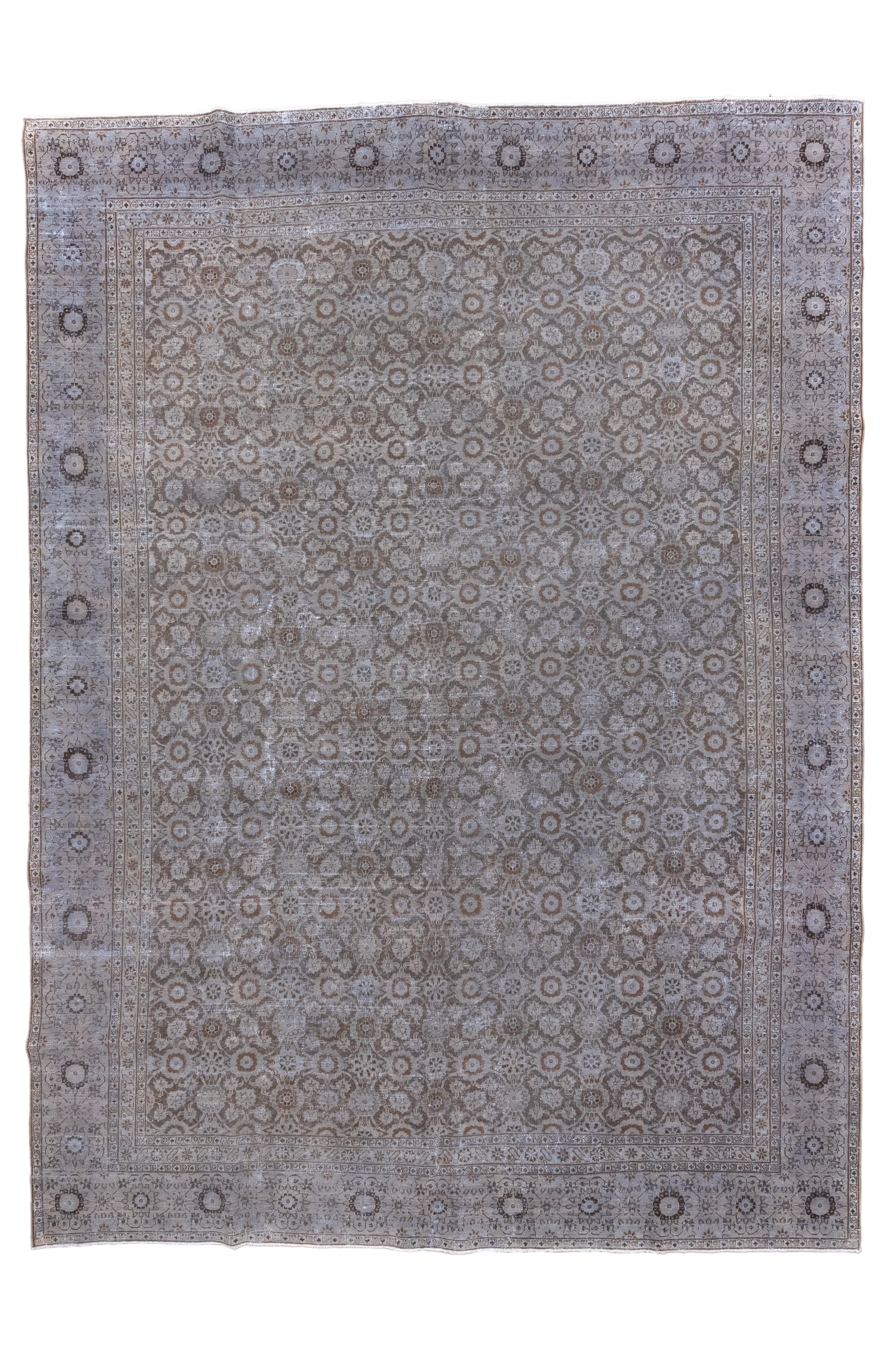 Das braune Feld ist deutlich, aber gleichmäßig abgenutzt, mit einem Minas-Khani-Allover-Muster aus Rosetten, das auch einen Hauch von Herati-Motiven enthält.  Kittgrüne, streifenförmige Bordüre mit blutroten, kleinen Rosetten, die von großen,