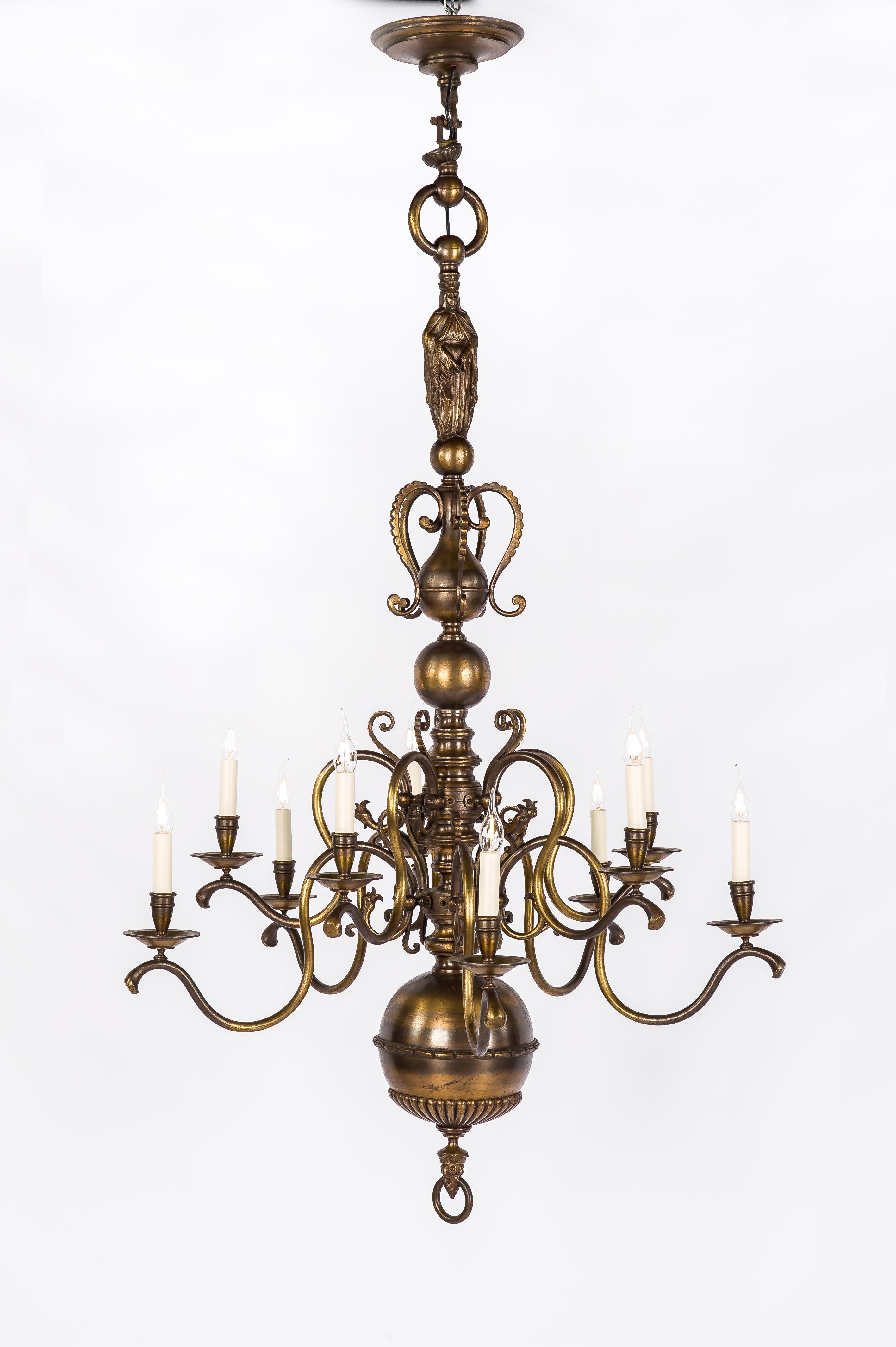 An exceptional tall two-tier Dutch or Flemish chandelier in patinated brass. The chandelier originates in The Netherlands or Belgium and was made in the early 1900s. It has the typical shape that Dutch or Flemish chandeliers are known for. It has a