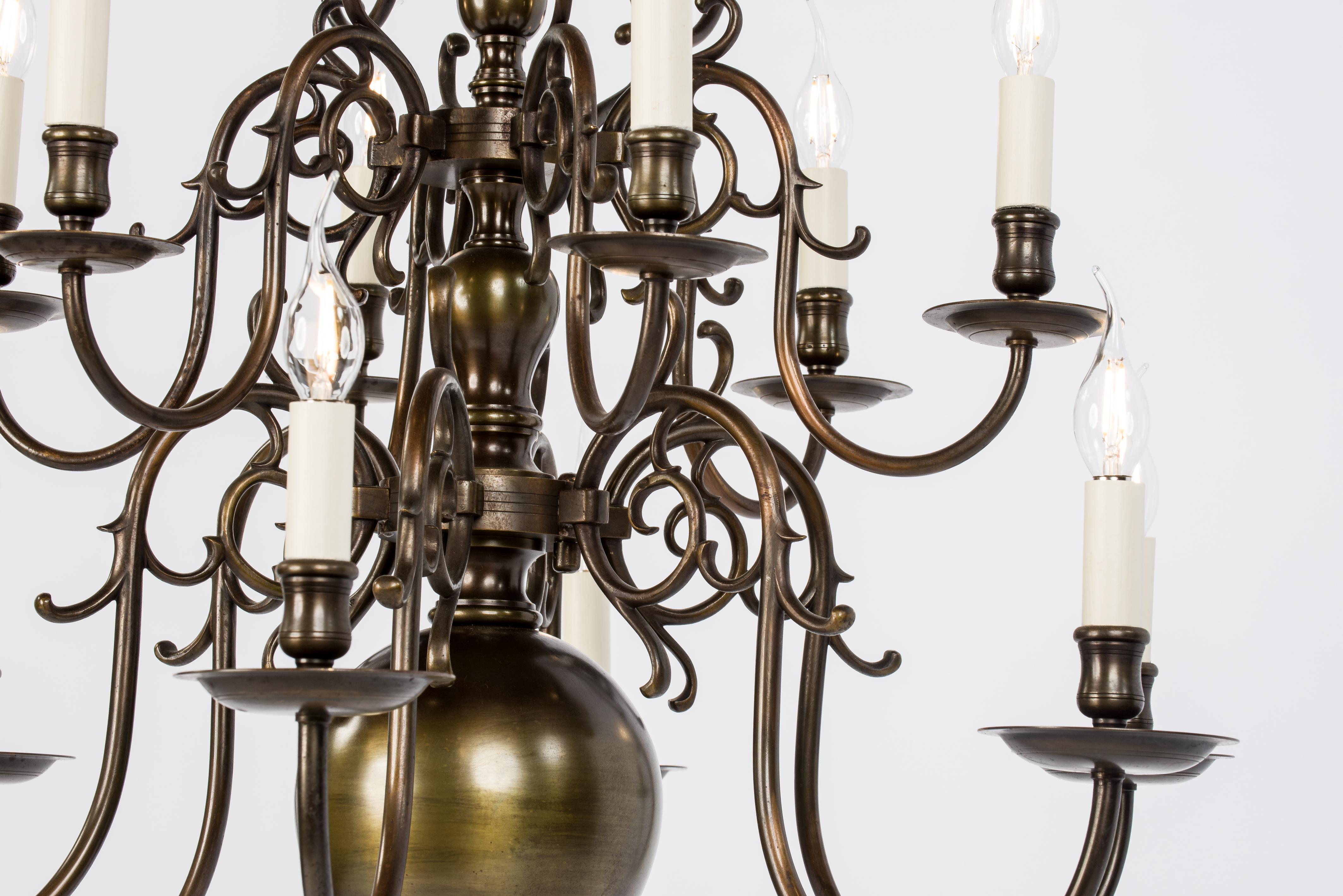 An exceptional tall three-tier Dutch chandelier in patinated brass. The chandelier originates in The Netherlands and was made in the early 1900s. It has the typical shape that Dutch or Flemish chandeliers are known for. It has a central column of