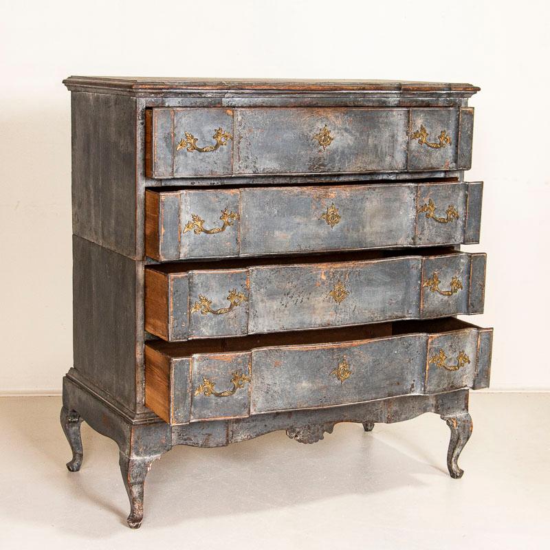 This antique tall baroque oak chest of drawers from Denmark features a serpentine front, brass hardware pulls and an exceptional (new) painted finish that appears as a blue-steel gray. Please examine the close up photos to fully appreciate the