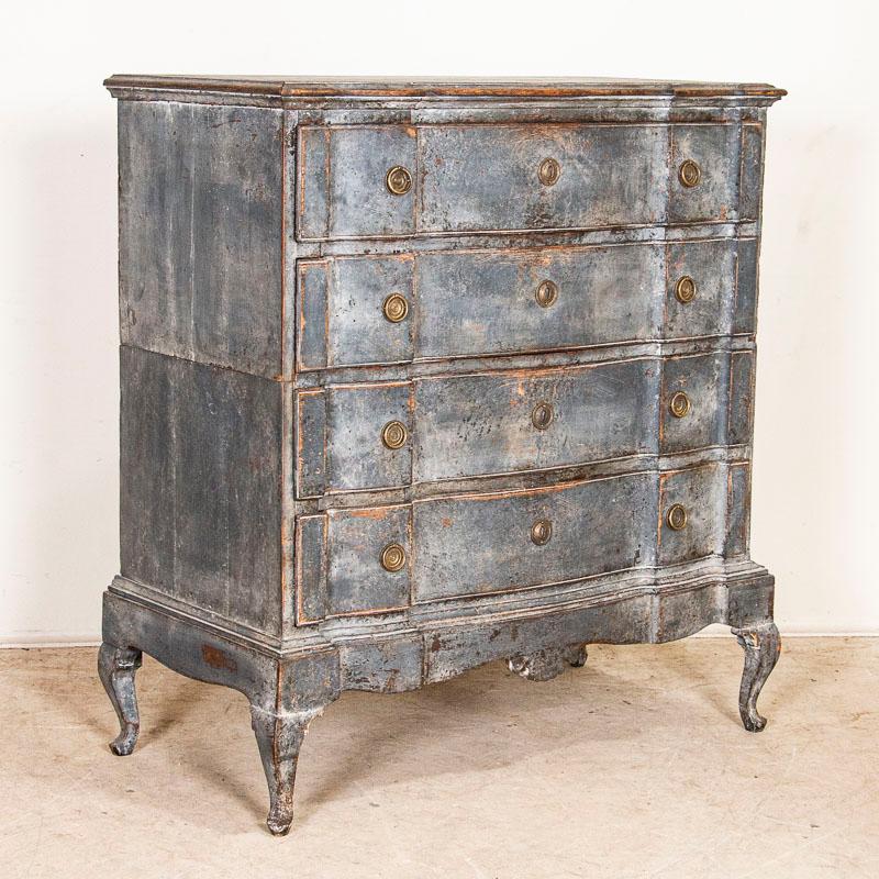 This antique tall baroque oak chest of drawers from Denmark features a serpentine front, brass hardware pulls and an exceptional original painted finish that appears as a blue-steel gray. Please examine the close up photos to fully appreciate the