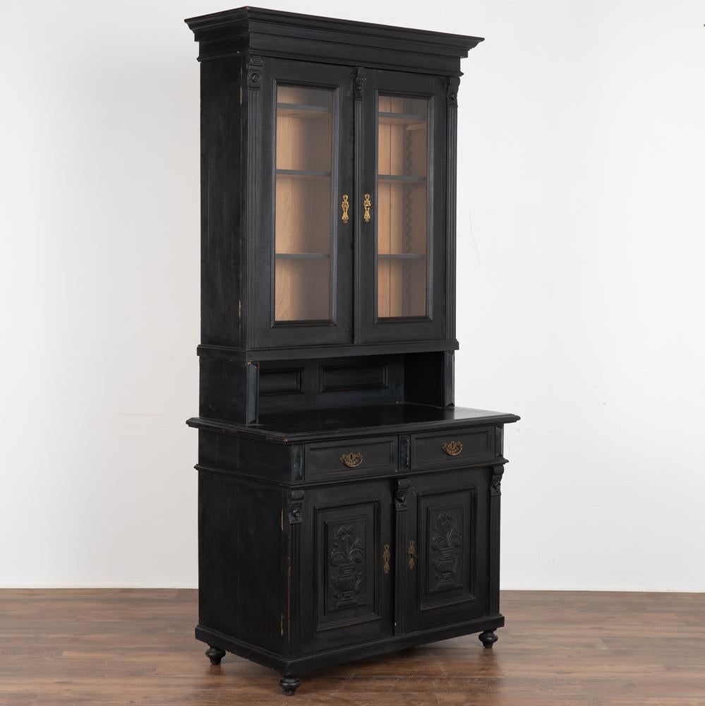 This antique pine display cabinet has been given new life with a professional black painted finish, lightly distressed to compliment the age and bring out the warmth of the pine. Note the decorative carved details that accent the lower doors.
At