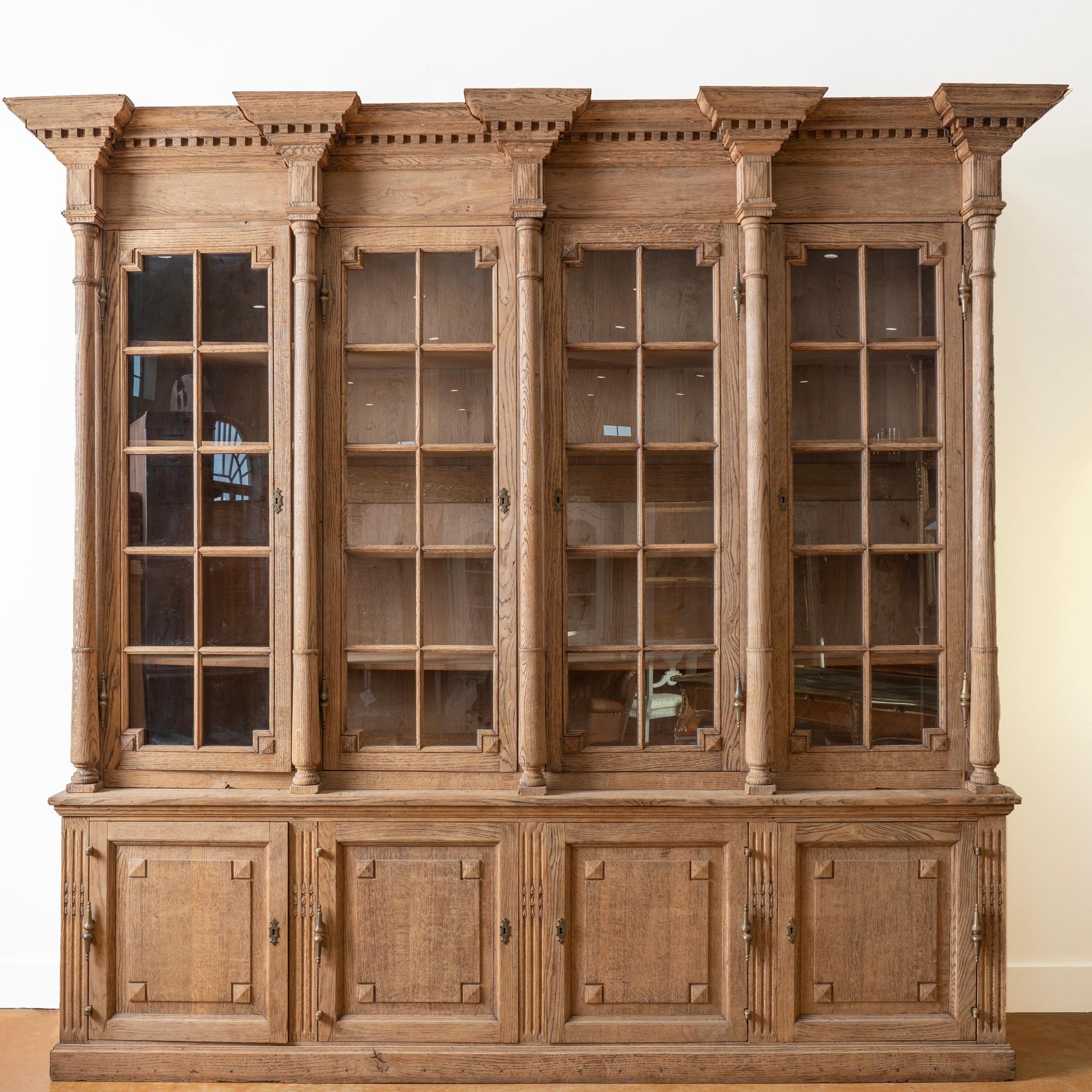 Large 8.5' tall/9' wide bleached oak bookcase display cabinet.
Turned columns, dentil molding along crown, lower cabinet storage includes interior 3 drawers.
Typical age related wear, nicks, scratches, separations, etc.
Adjustable shelving,