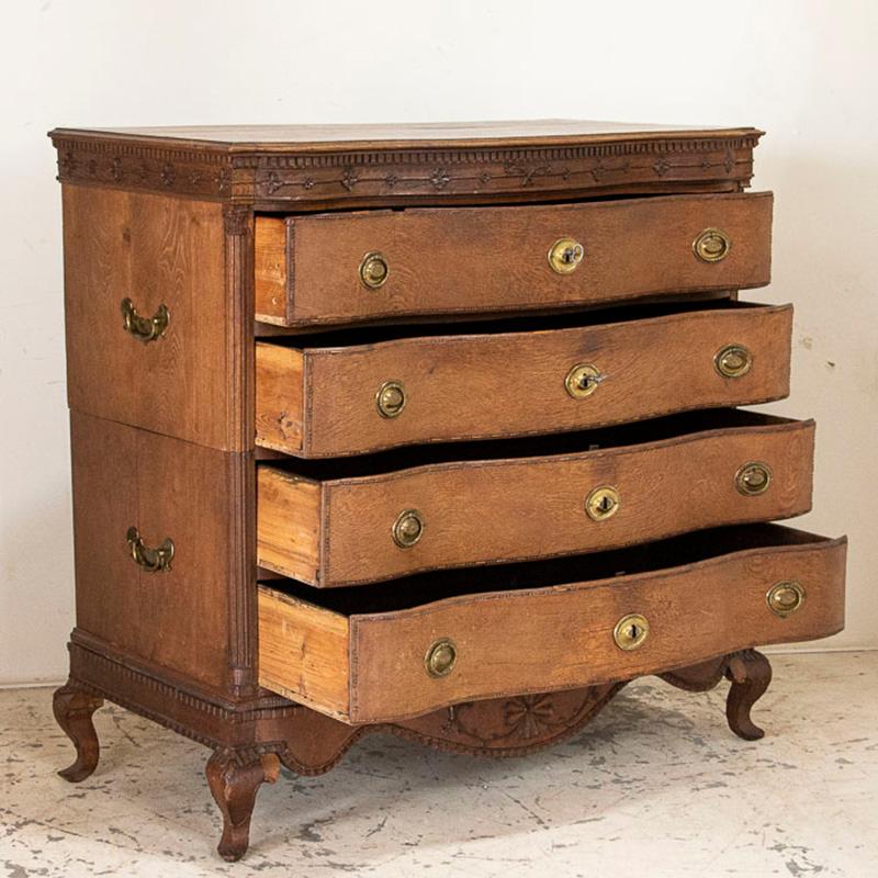 This attractive chest of drawers has delightful carving along the top and bottom with cabriolet legs, adding a slight romantic touch the solid oak. Notice it is built in 3 sections; the lower base with feet, and 2 upper sections with 2 drawers each.