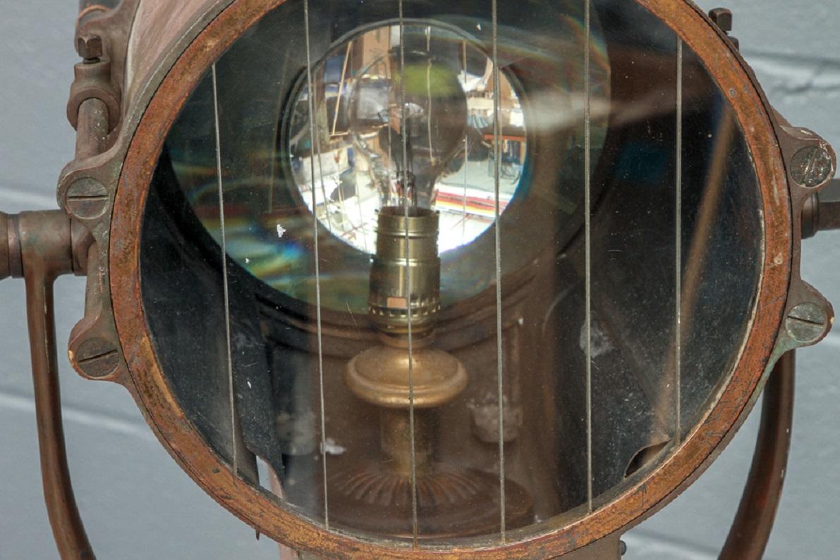 Projector No. 2180 DL 41407, Type HC by General Electric, Schenectedy N.Y., U.S.A. The copper cased lantern with brass mounts, glass light and black painted wood handles. Mounted on a tall black iron stand. 

Good condition with expected signs of
