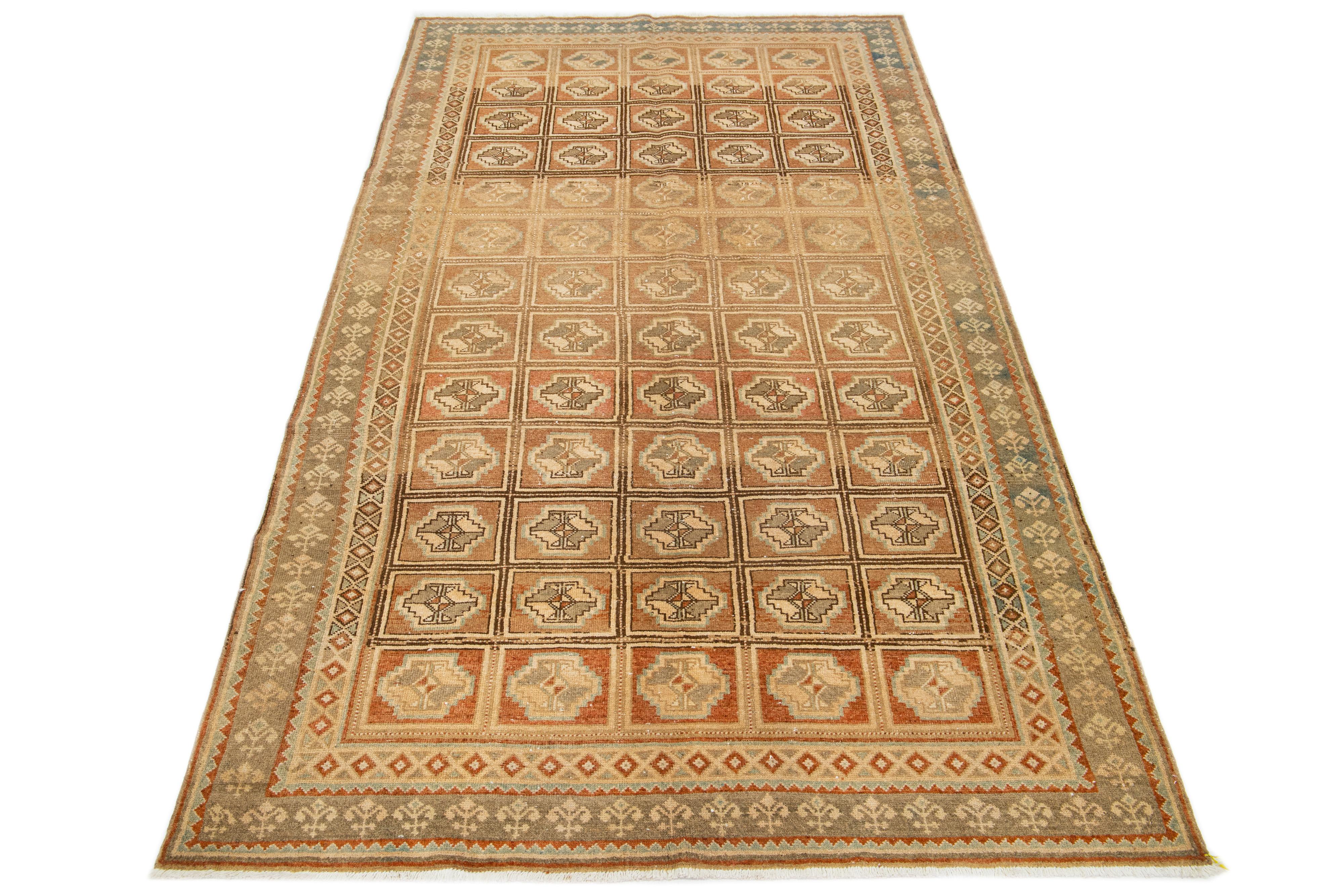 Beautiful vintage Persian hand-knotted wool rug with a tan color field. This piece has a designed frame with terracotta, blue, and beige accents in a gorgeous all-over geometric pattern.

This rug measures 5'3