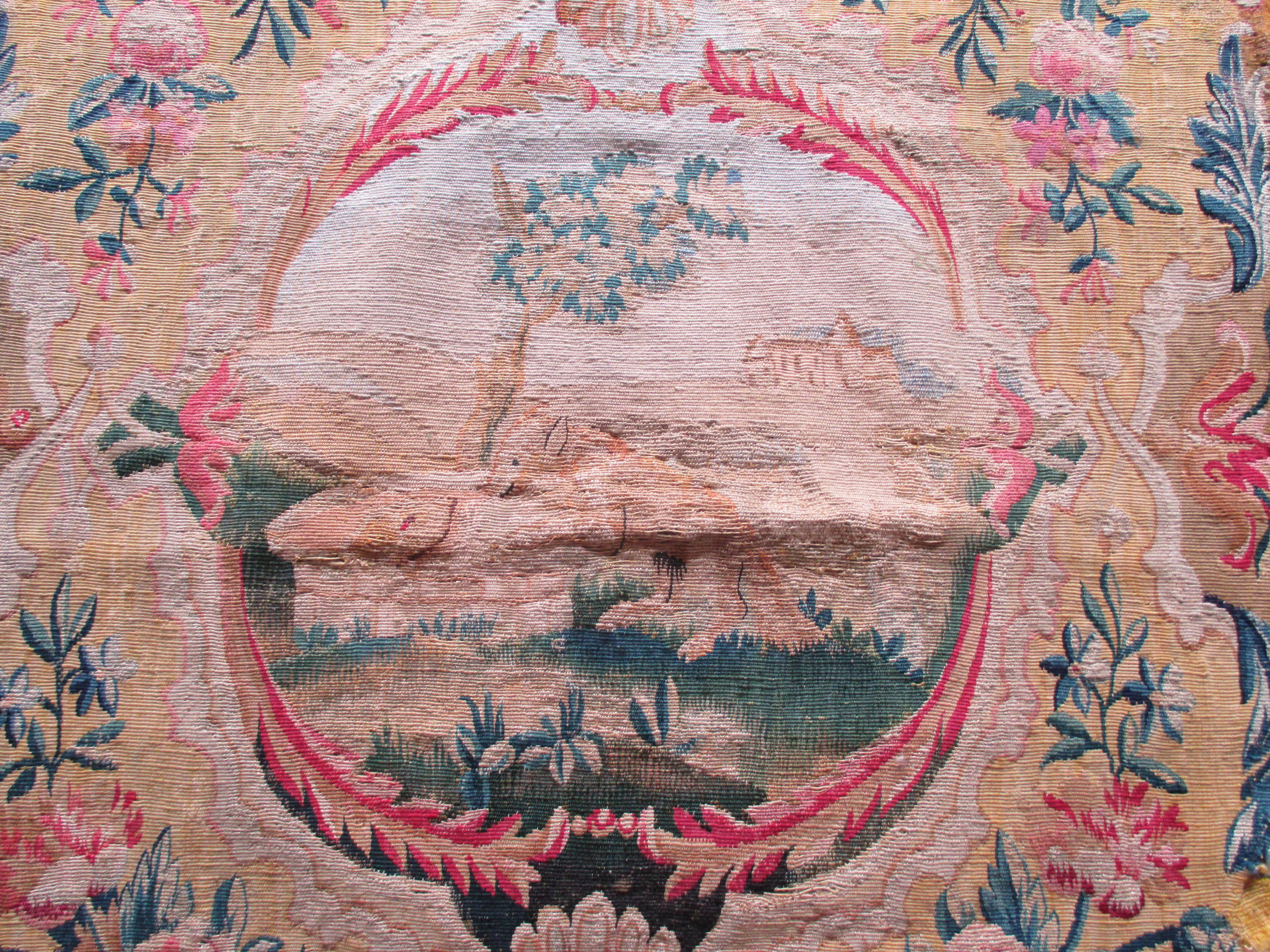 Antique tapestry fragment picturing center oval medallion with bucolic scene
In shades of red, yellow, blue, orange, pink and taupe. Includes a fox in the center with a castle in the background.
Sold as is, needs restoration and backing. 
Ideal