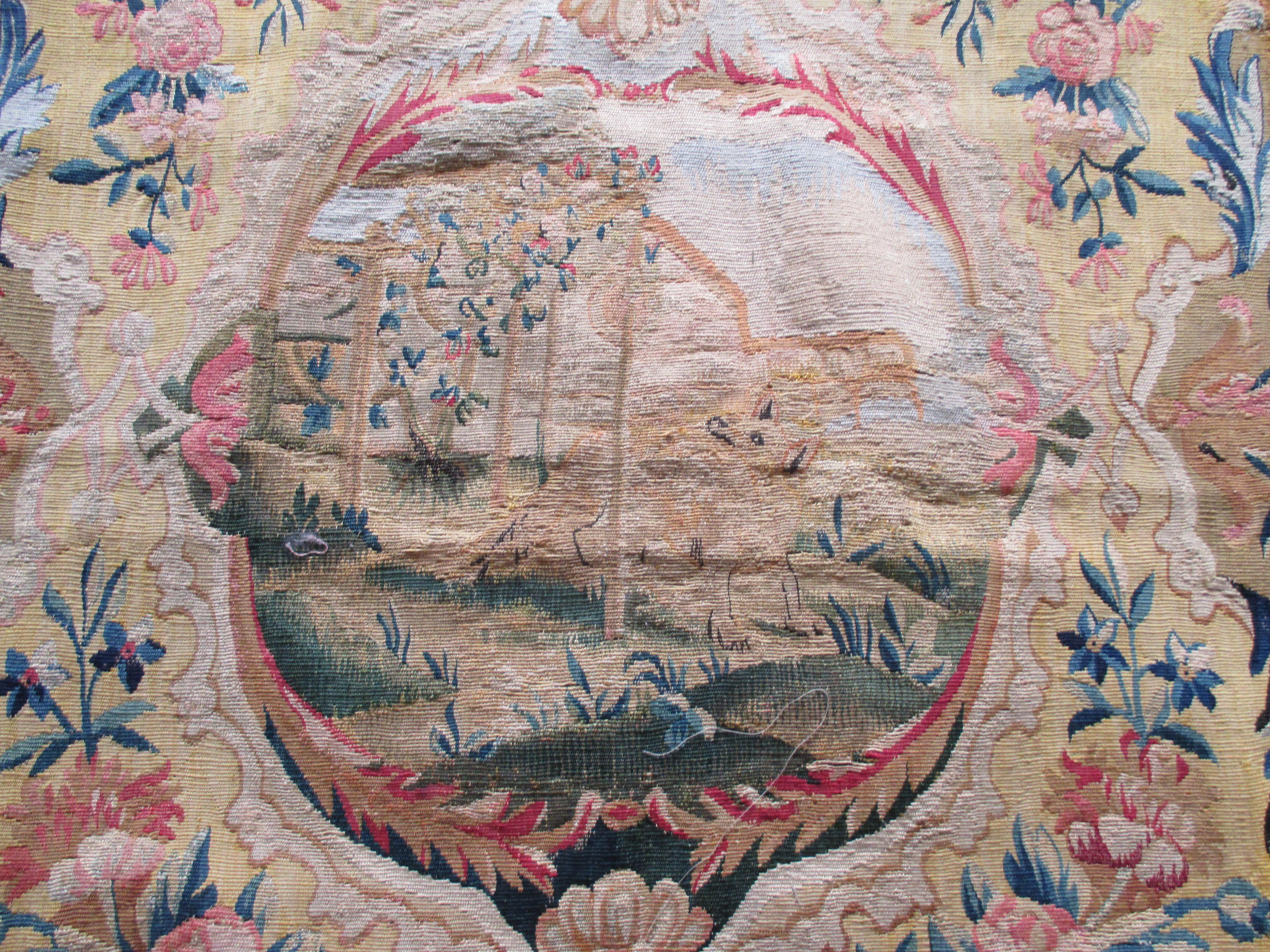 Antique tapestry fragment picturing center oval medallion with bucolic scene
In shades of red, yellow, blue, orange, pink and taupe.
Needs restoration. Sold as is.
With a fox and birds center stage and a design of pink flowers and blue vines