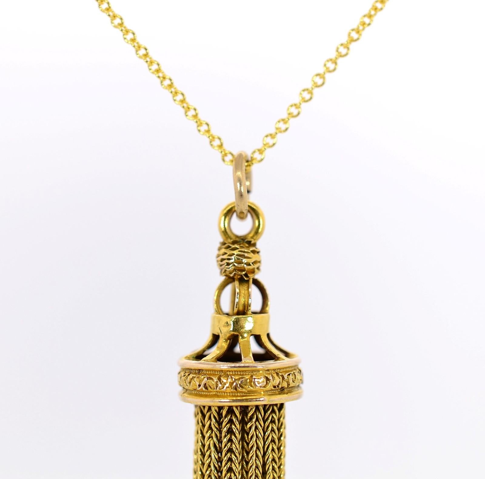 Classic Victorian, this 1890s era 14KT yellow gold pendant exudes antiquity.  The cap is adorned with hand engraving, and the dangling fox tail chains gently sway to-and-fro.  Pendant is suspended from 18