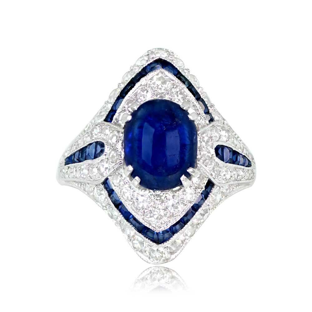Elevate your style with this elongated Art Deco masterpiece. The focal point is a captivating 1.50-carat cabochon sapphire, beautifully prong-set at the center. It's surrounded by halos of single-cut diamonds and calibre-cut sapphires, creating a