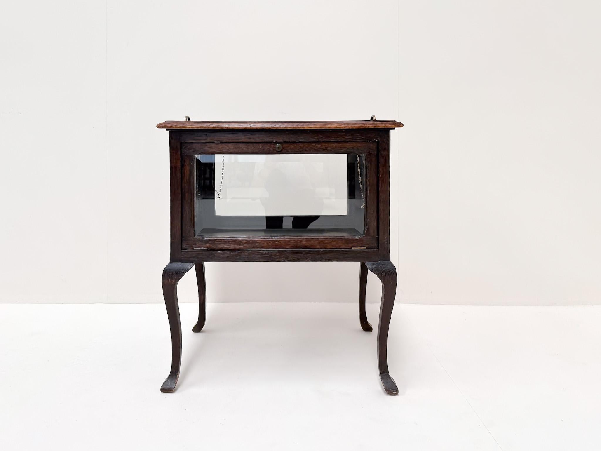 Affascinante mobile da tè dei primi del Novecento con pannelli in vetro smussato (geslepen glas) su tutti i lati. Il pezzo è dotato di un vassoio di servizio rimovibile con maniglie sulla parte superiore e di ante in vetro che si aprono su tutti i