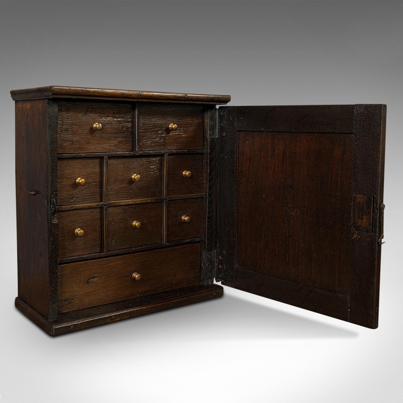 This is an antique tea cabinet. An English, oak spice or apothecary case, dating to the Georgian period, circa 1800.

Pleasingly heavy Georgian piece
Displays a desirable aged patina
Dark English oak with fine grain interest
Wisps of medullary