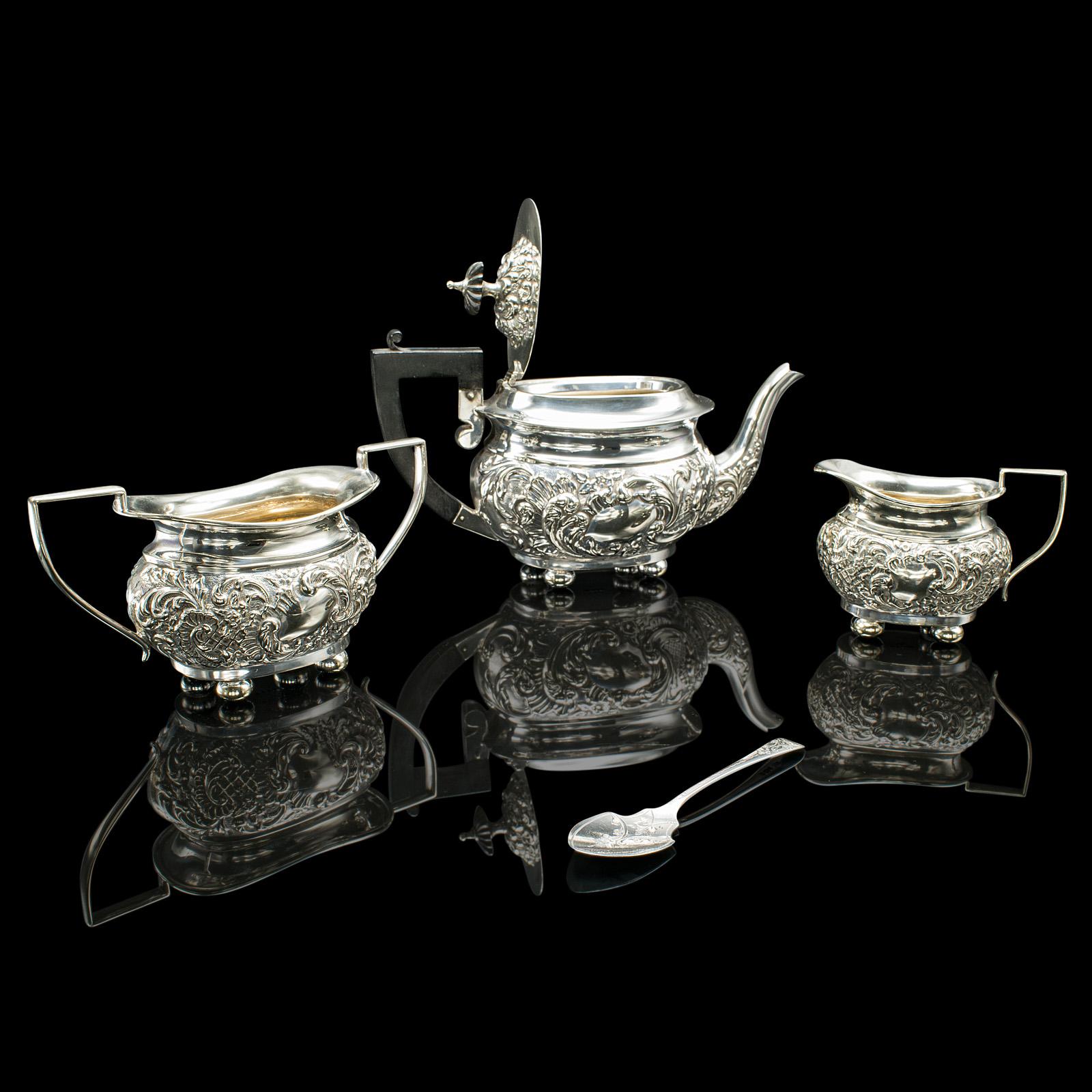 
This is an antique tea serving set. An English, silver plated teapot, sugar dish and cream jug, dating to the Edwardian period, circa 1910.

Pleasingly decorative, Edwardian afternoon tea service with silver spoon
Displaying a desirable aged patina