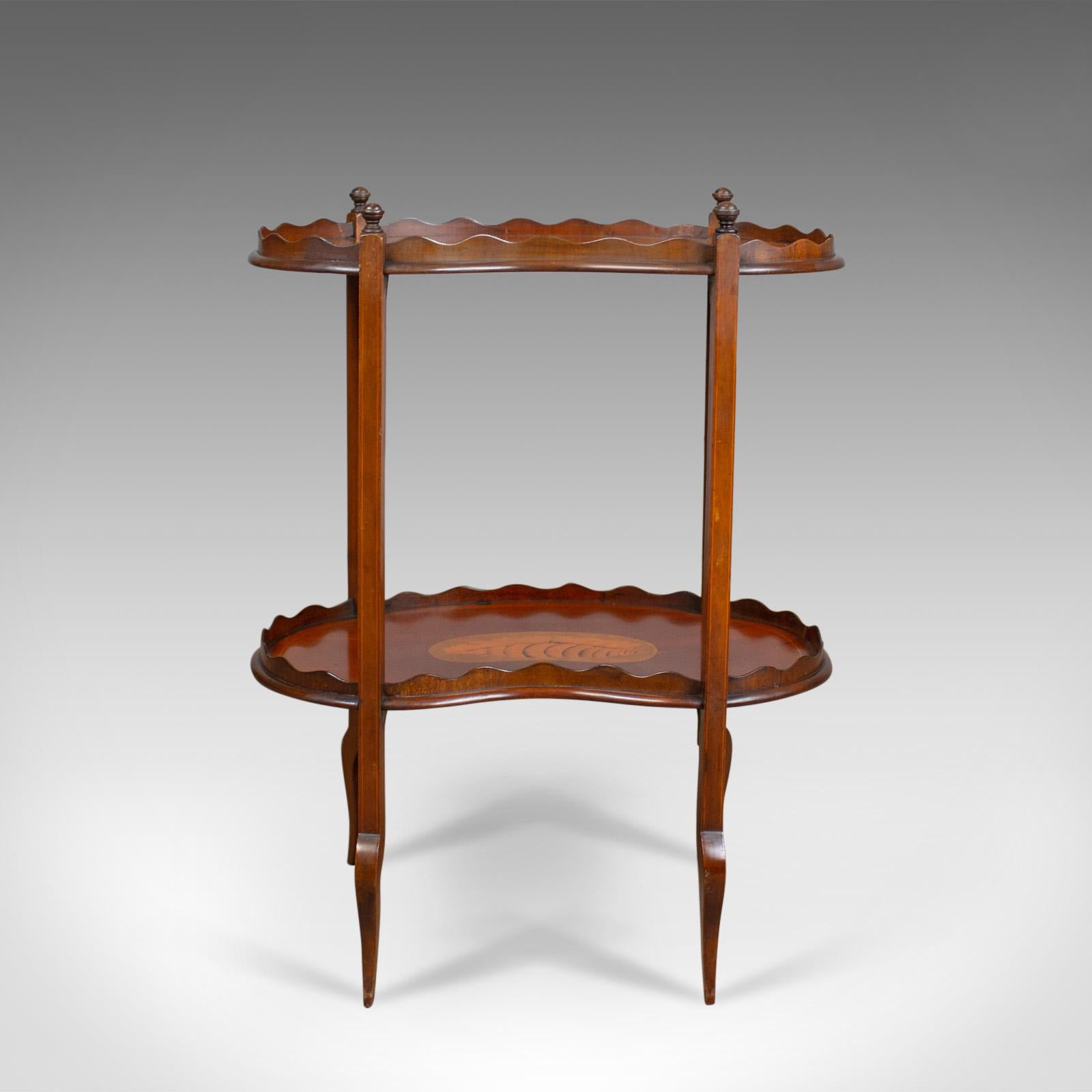 This is an antique tea table, an English, Edwardian, two tier, galleried, side table in mahogany from the early 20th century, circa 1910.

Attractive, well figured, mahogany
In russet hues with a desirable aged patina
Raised on appealing,
