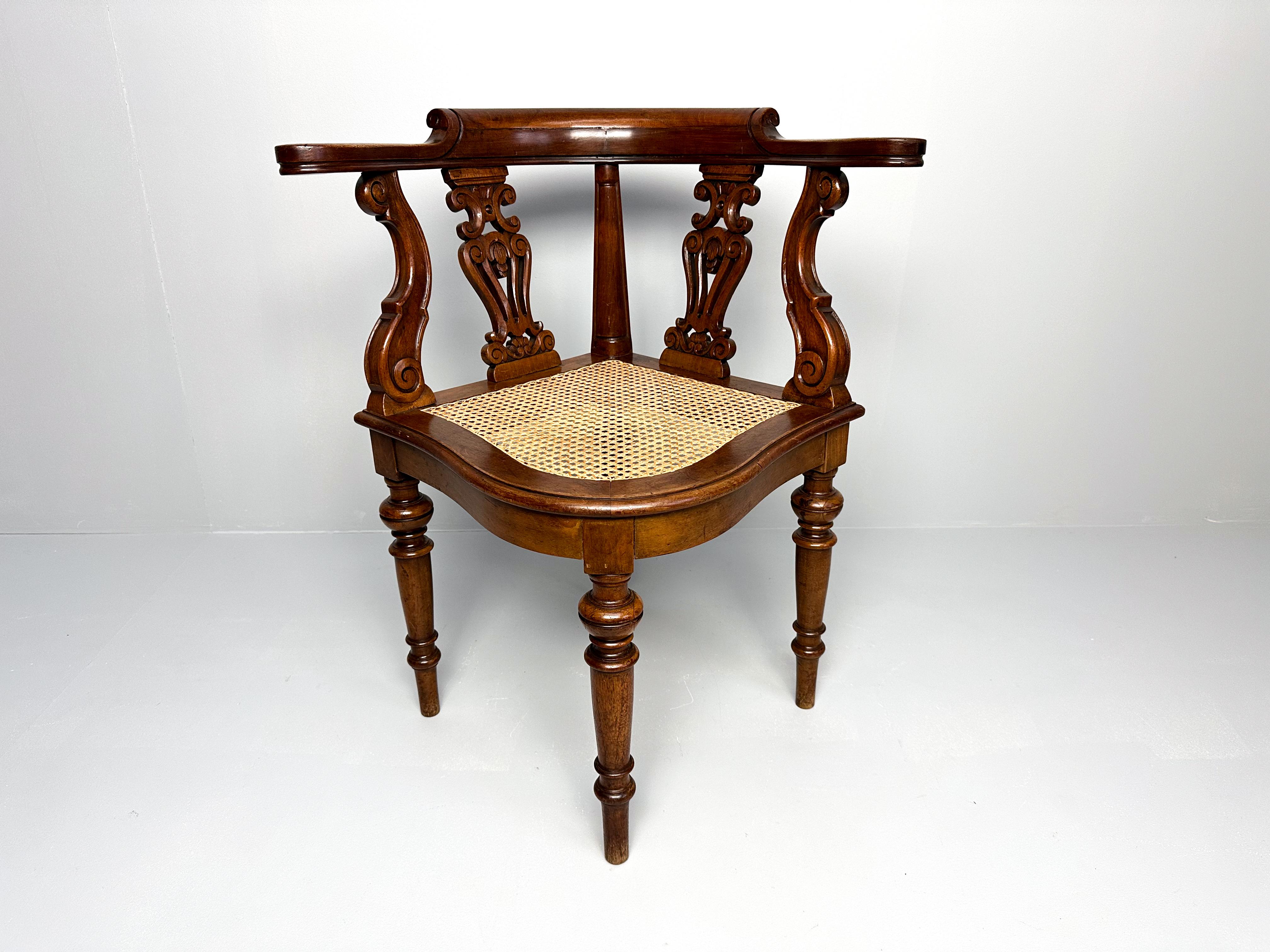 Gorgeous teak corner chair, featuring an intricately carved backrest and a classic webbing seat. Supported by elegantly tapered legs, this piece adds timeless style and warmth to any space. Perfect for cozy corners or as a standout accent chair in