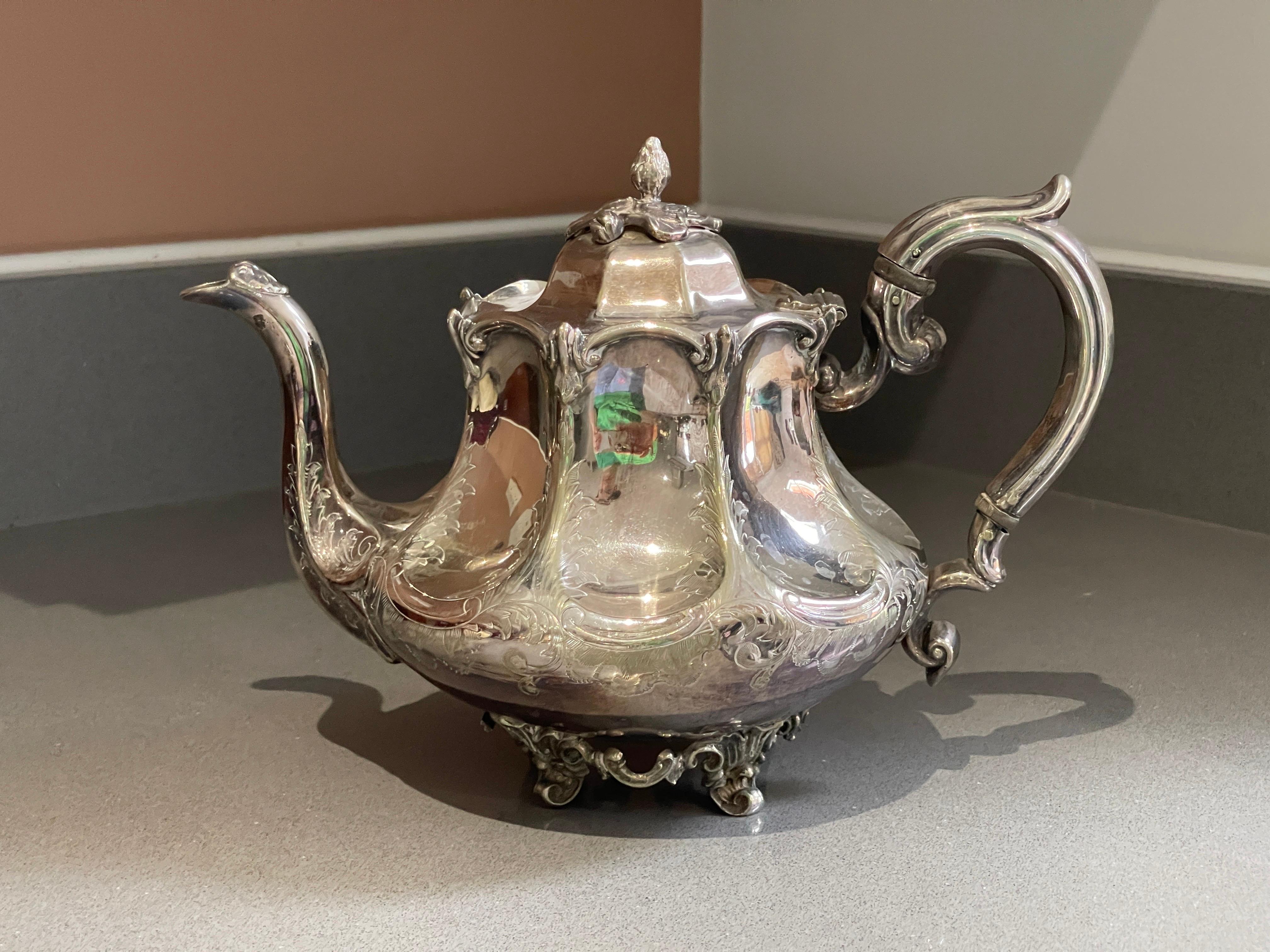 An antique tea set and a silver-plated teapot that is beautifully designed and created are suitable for elegant serving. With lid pressed, cast and chased, gold gilding on the inside. Oval, domed body on short, curved feet with hinged, vaulted lid.