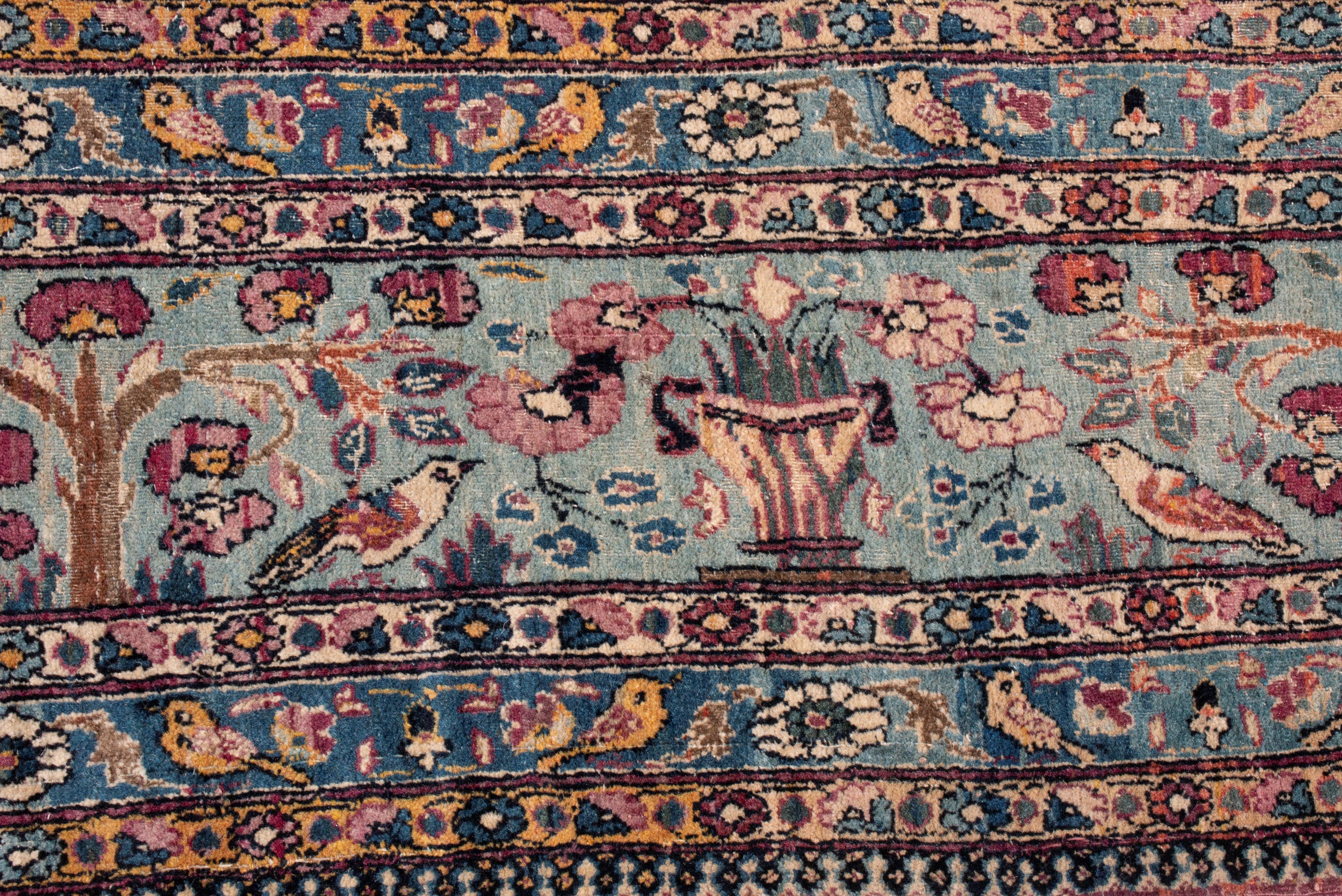 This antique Tehran wool rug has a surprisingly similar color scheme to neoclassicist Aubusson rugs, though the design is indicatively Persian. As a piece from 1910, the minutia of the border resembles a millefleur style, but the forest imagery,