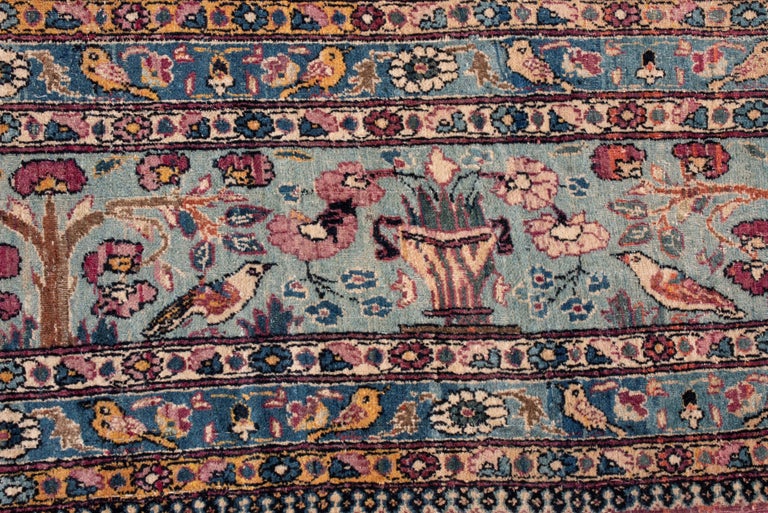 This antique Tehran wool rug has a surprisingly similar color scheme to neoclassicist Aubusson rugs, though the design is indicatively Persian. As a piece from 1910, the minutia of the border resembles a millefleur style, but the forest imagery,
