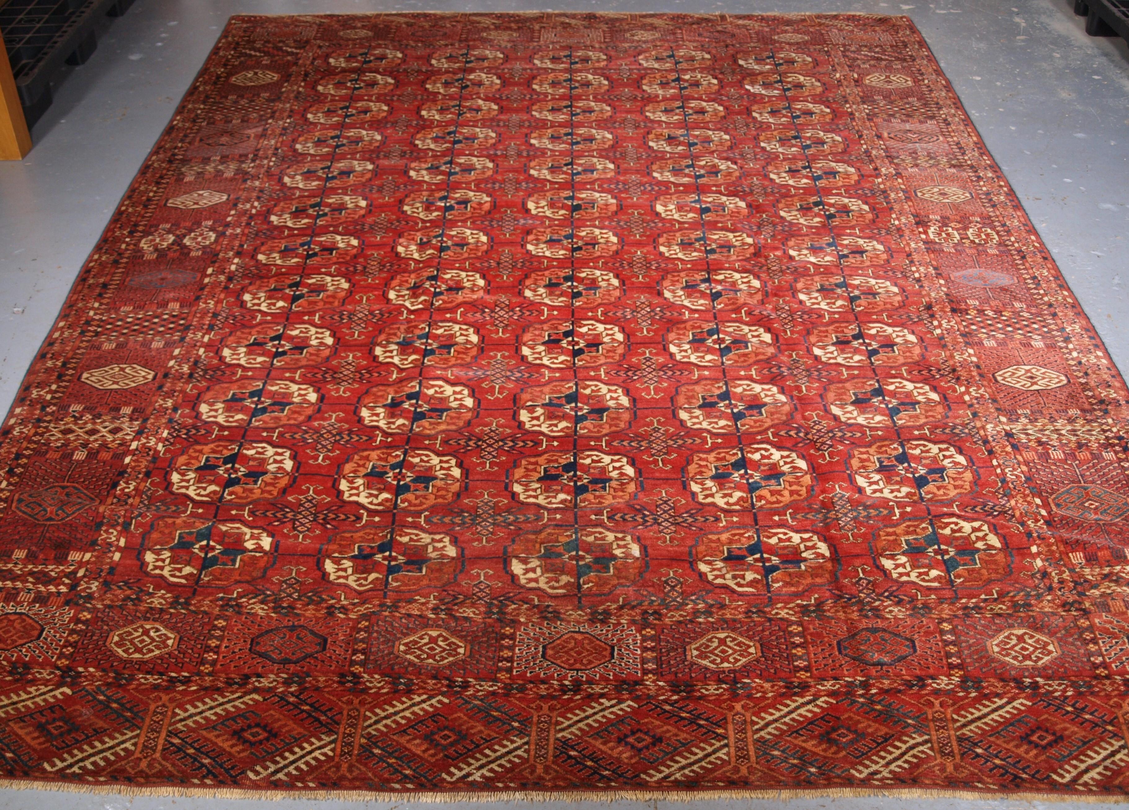 Antique Tekke Turkmen main carpet with 5 rows of 12 large round Tekke guls. A good Tekke main carpet of room size with a warm madder red field and large well drawn large Tekke guls. The minor guls are of an early form with the complete 'bow and