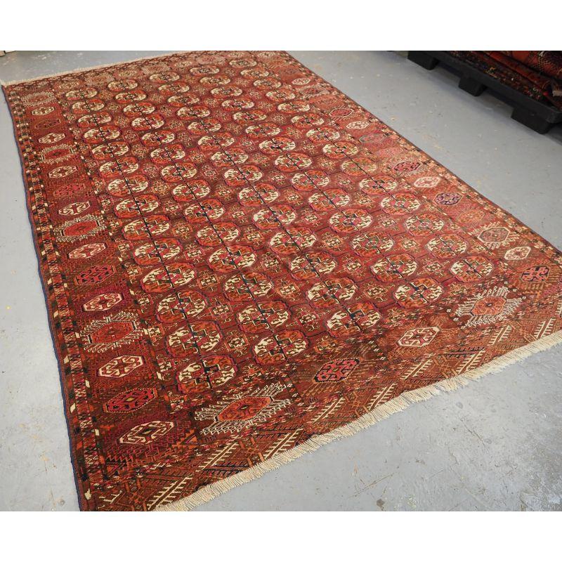 Antique Tekke Turkmen main carpet with 5 rows of 14 Tekke guls.

The carpet has a soft madder brown / red ground colour, the design is traditional Tekke Turkmen. The border is of the Turkmen octagon and sunburst design. The carpet has highlights