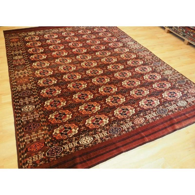 An excellent Tekke main carpet of small room size with 5 rows of 11 guls. The rich deep madder red field has well drawn large round Tekke guls. The border is of the octogon design and has many tribal filler elements. Note the piled elem panels at
