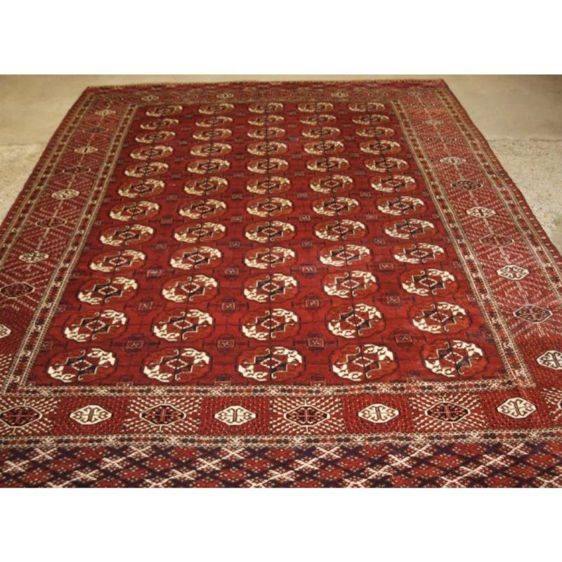 Antique Tekke Turkmen main carpet with 5 rows of 12 guls.

A good Tekke main carpet of room size, the clear madder red field has well drawn large Tekke guls. The border is of the sunburst design. Note the very decorative piled elem panels at each