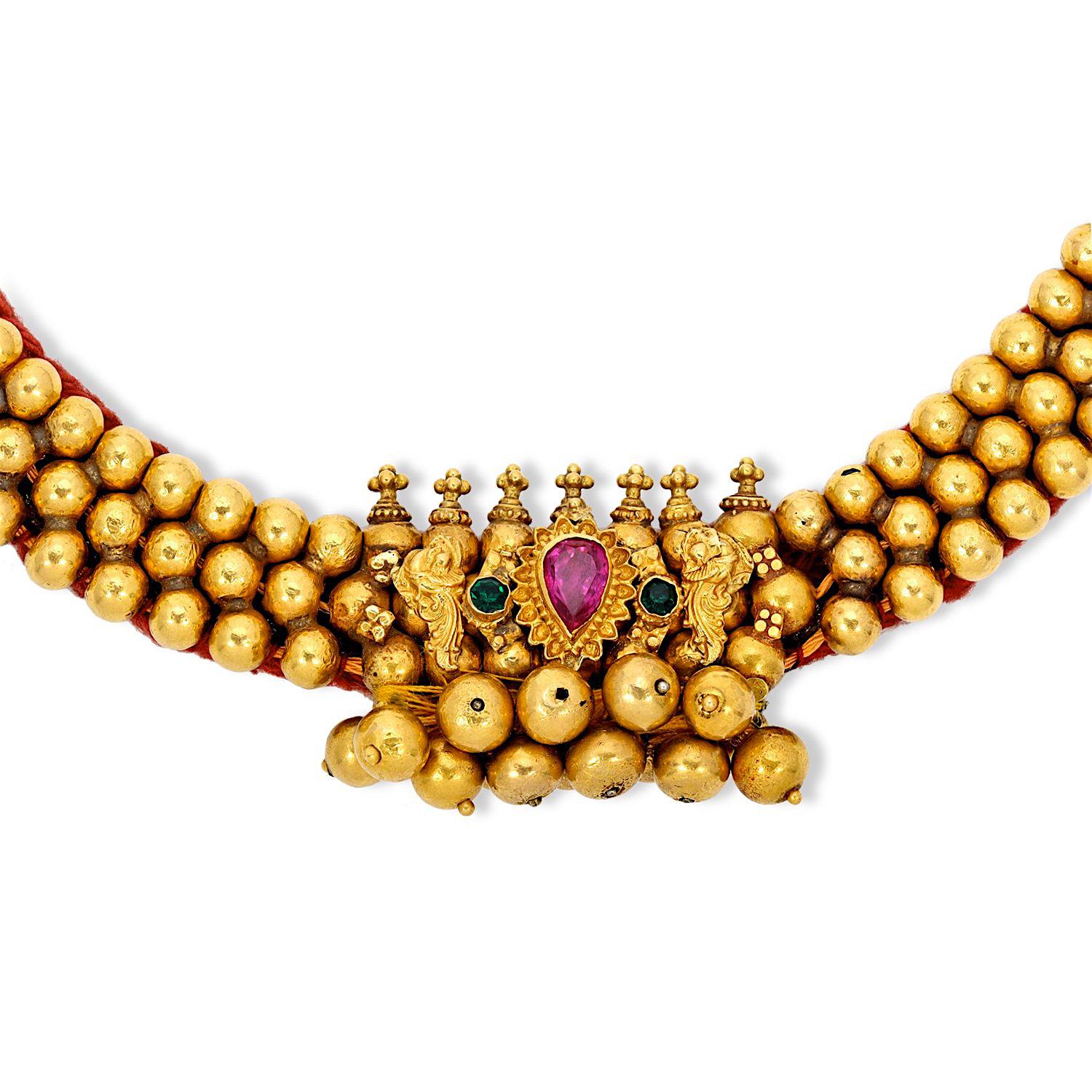 Part of a wedding dowry set from a temple in the south of India, this necklace is at least 100 years old and in pristine condition with the original adjustable cord and features semi precious stones in beautiful hues of magenta pink and emerald