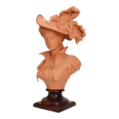 Buste antique en terre cuite représentant une débutante en tenue victorienne, sur socle en bois, vers 1910