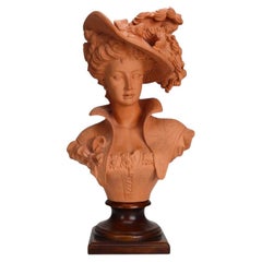 Buste antique en terre cuite représentant une débutante en tenue victorienne, sur socle en bois, vers 1910