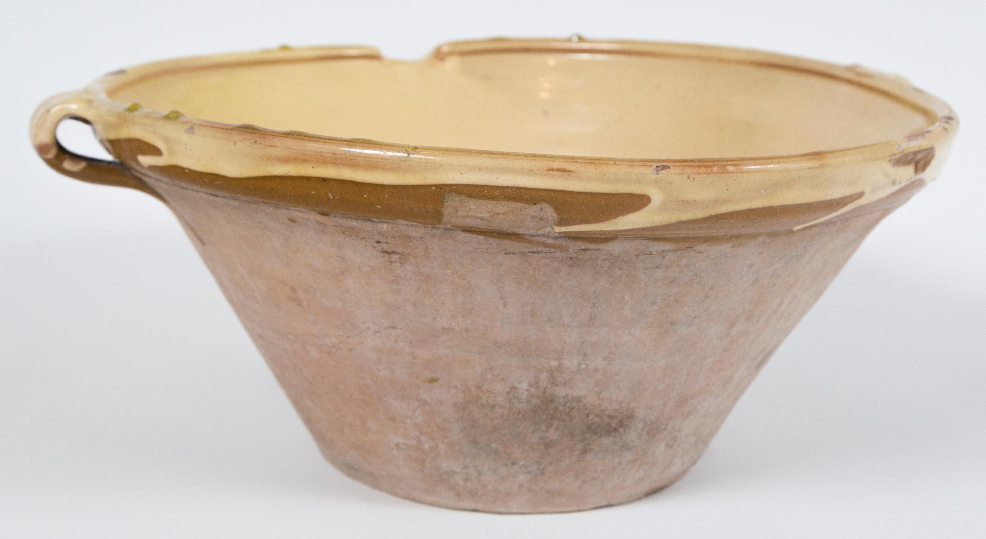 Antique terra cotta 'Tian' bowl, France, late 19th century. A large size 'Tian' with handles and spout. Pale yellow glaze on the interior and rim, unglazed exterior. Originating in the south of France, the 'Tian' was used as a mixing bowl,