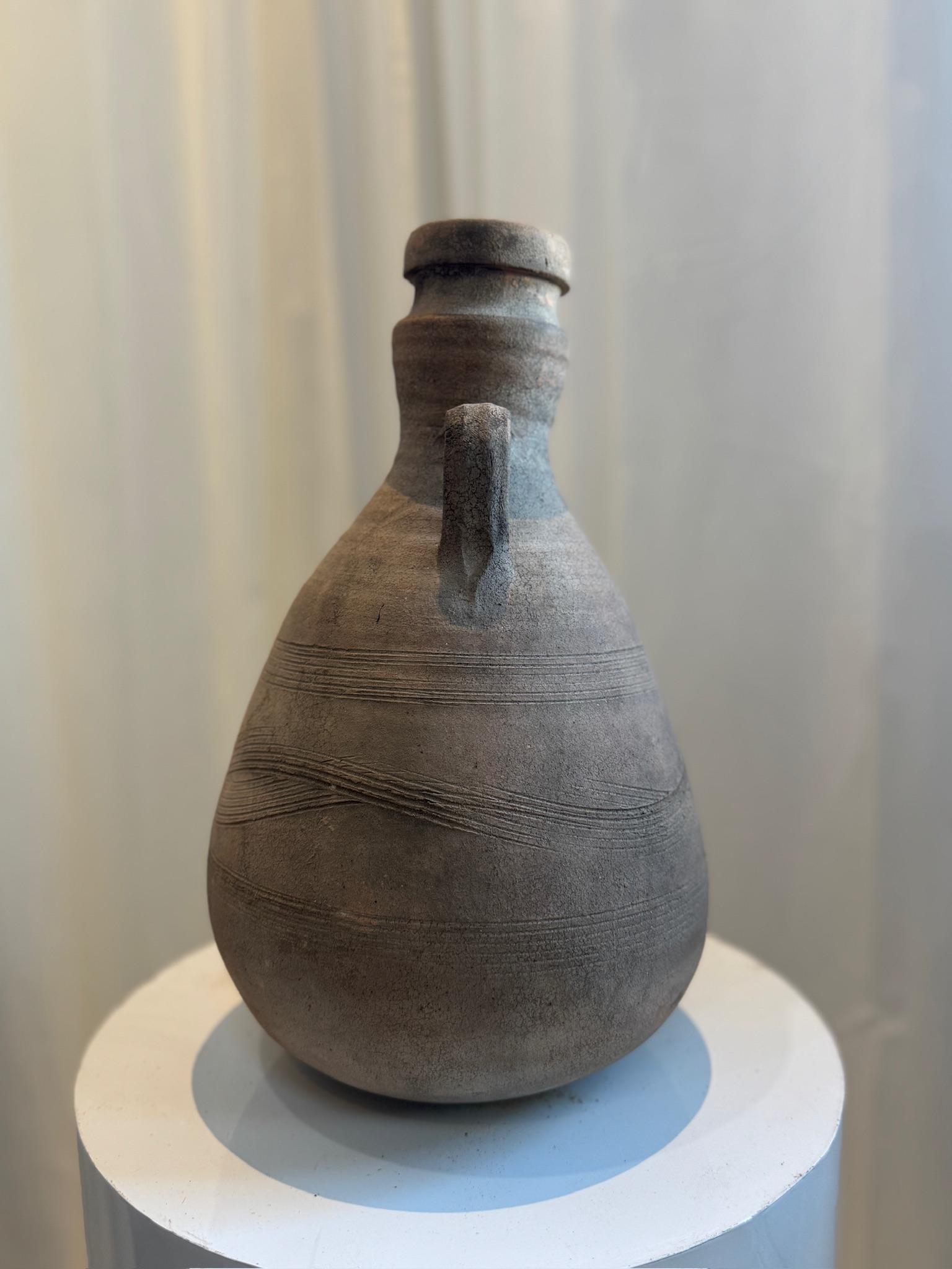 Diese antike Terrakotta-Amphore erinnert an die Kunstfertigkeit der klassischen römischen Töpferei und verkörpert sowohl historische Eleganz als auch zeitlose Handwerkskunst. Mit ihrem anmutig verjüngten Körper, dem schmalen Hals und den zart