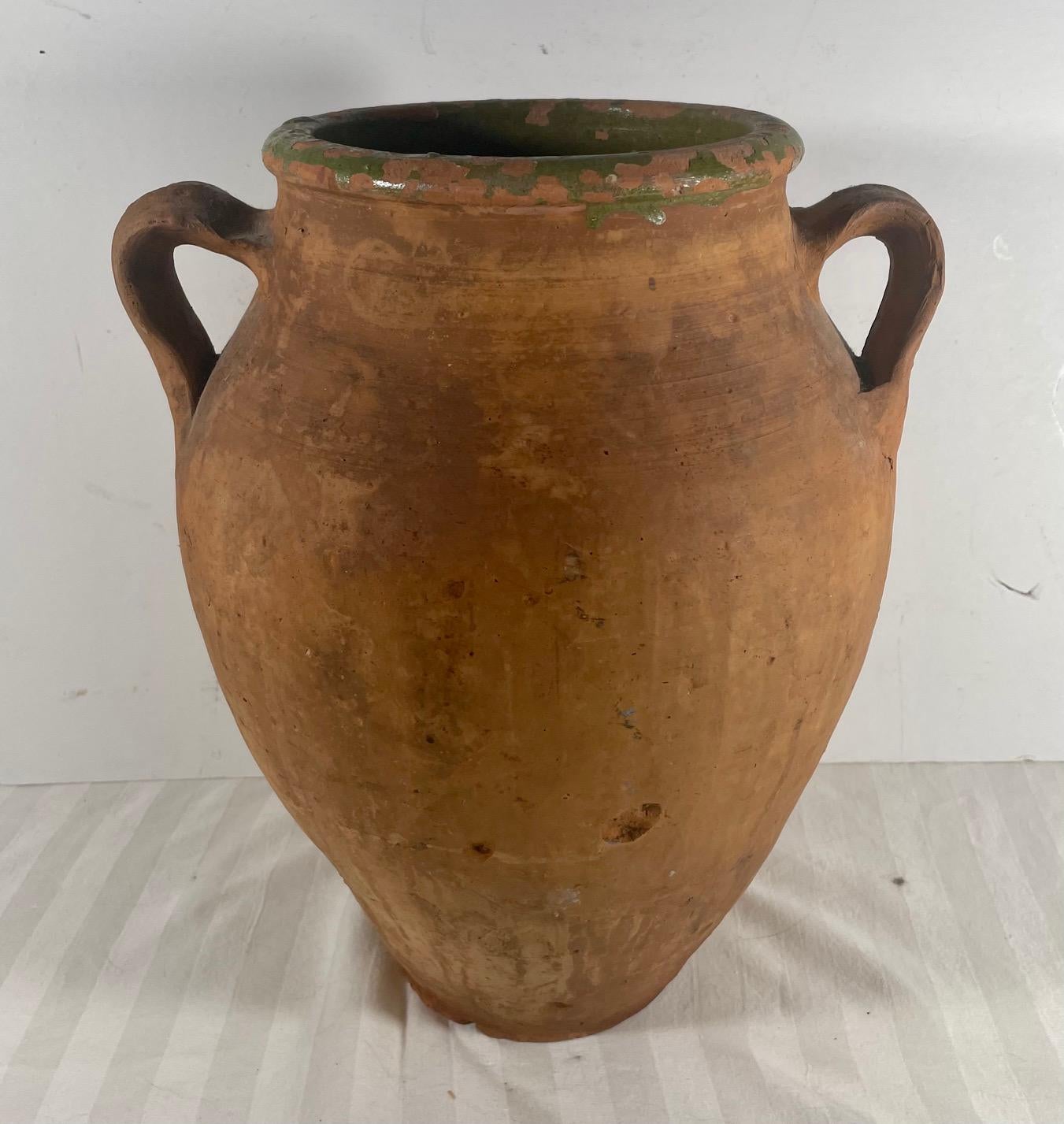 Antique Terracotta Amphora Olive Oil Pot.  

.  This European terracotta amphora was probably used for the storage and transport of olive oil.  The double handled jug has retained traces of green paint around the mouth and shows the natural