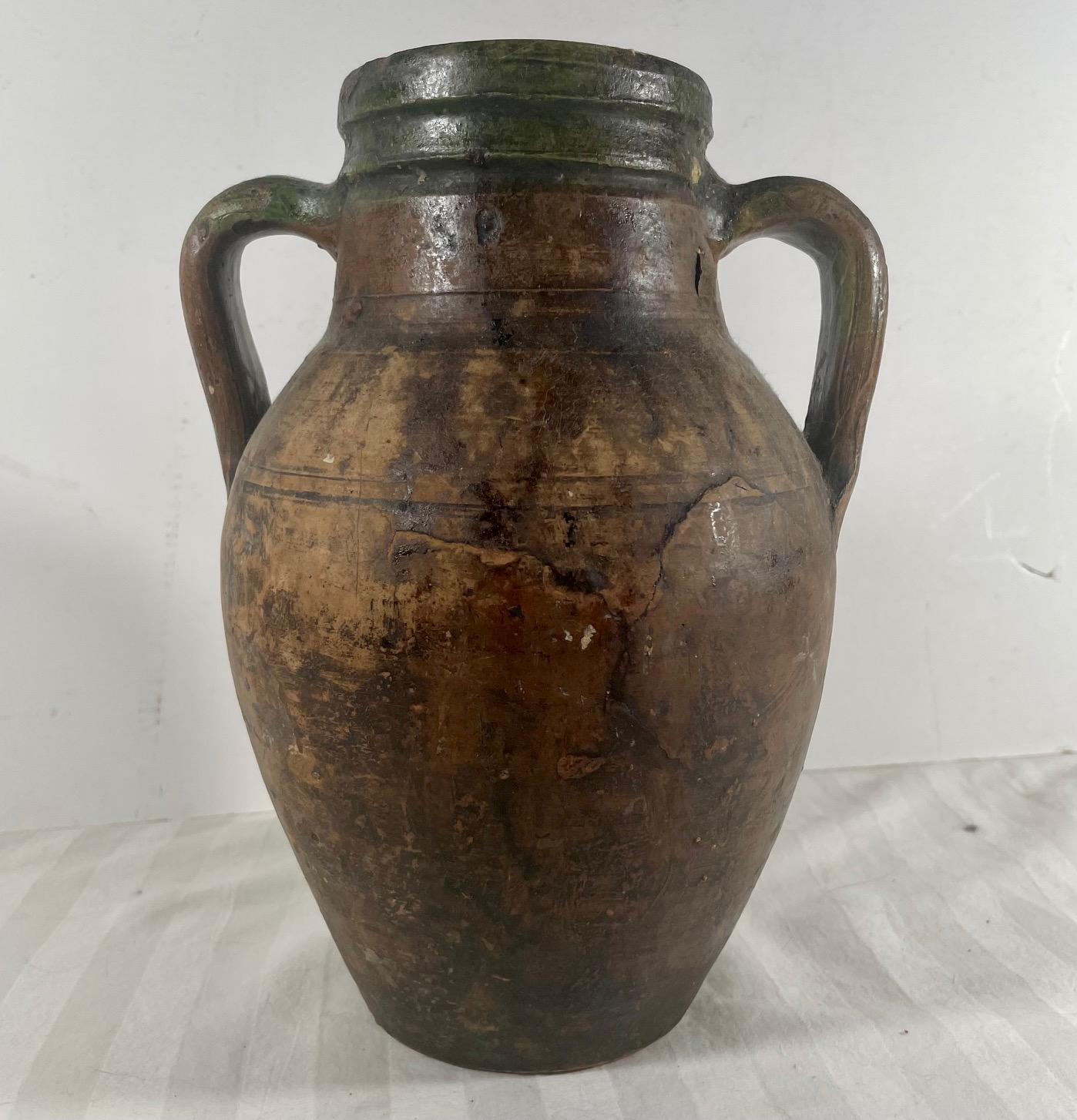 Antike Terrakotta Amphora Olivenöl Topf. 

Diese europäische Terrakotta-Amphore wurde wahrscheinlich für die Lagerung und den Transport von Olivenöl verwendet. Der Krug mit doppeltem Henkel ist um die Mündung herum grün bemalt und weist am
