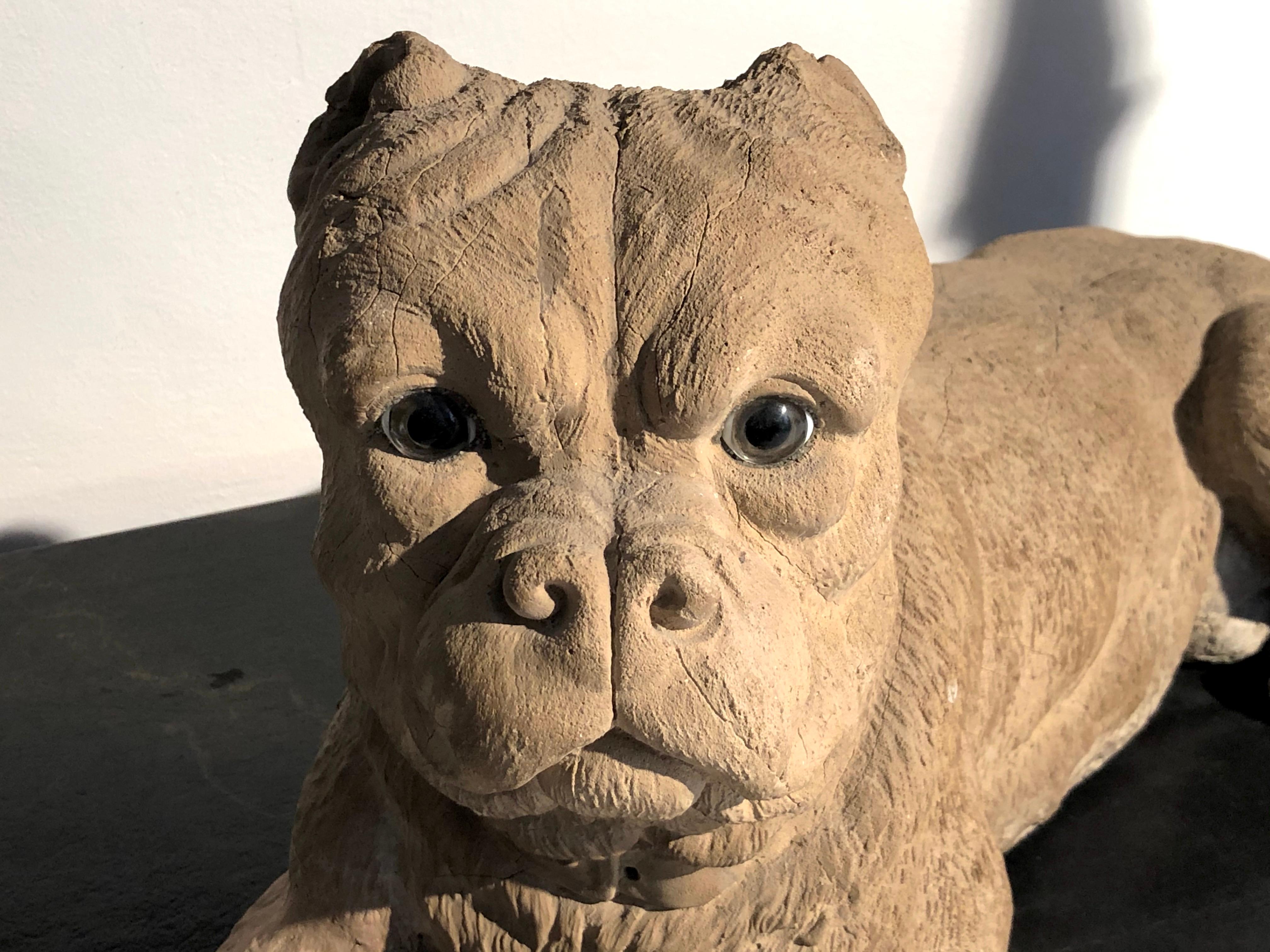 The finely modeled sculpture in the shape of a English bulldog is made out of terracotta and has glass eyes. It was made in England between circa 1860-1870.
  