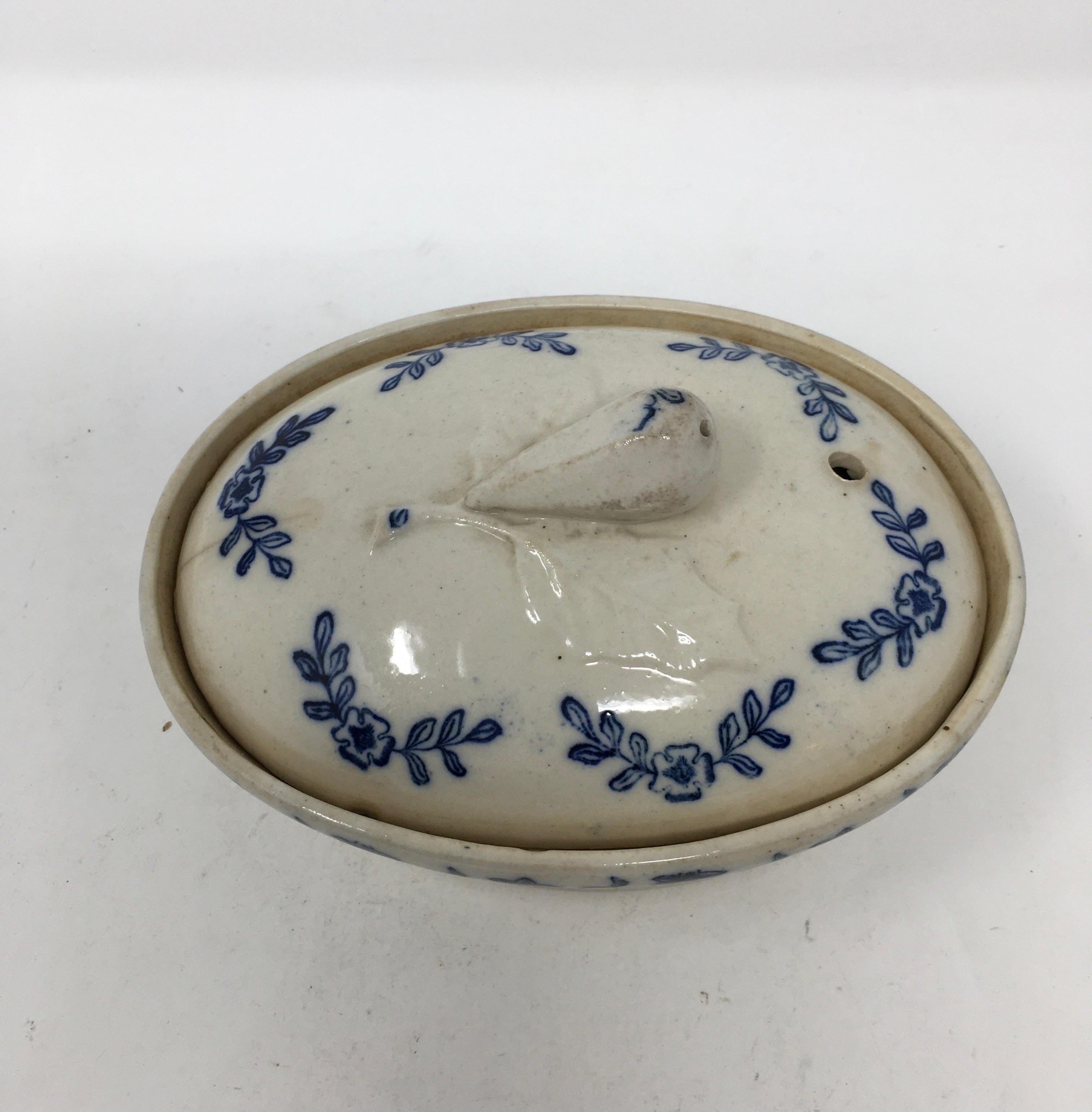 Found in France, this antique ironstone Terre de Fonte small covered casserole dish has lovely blue floral transferred design. The piece is complete with a pull handle in the shape of fruit on the lid and two handles on the casserole itself. Signed
