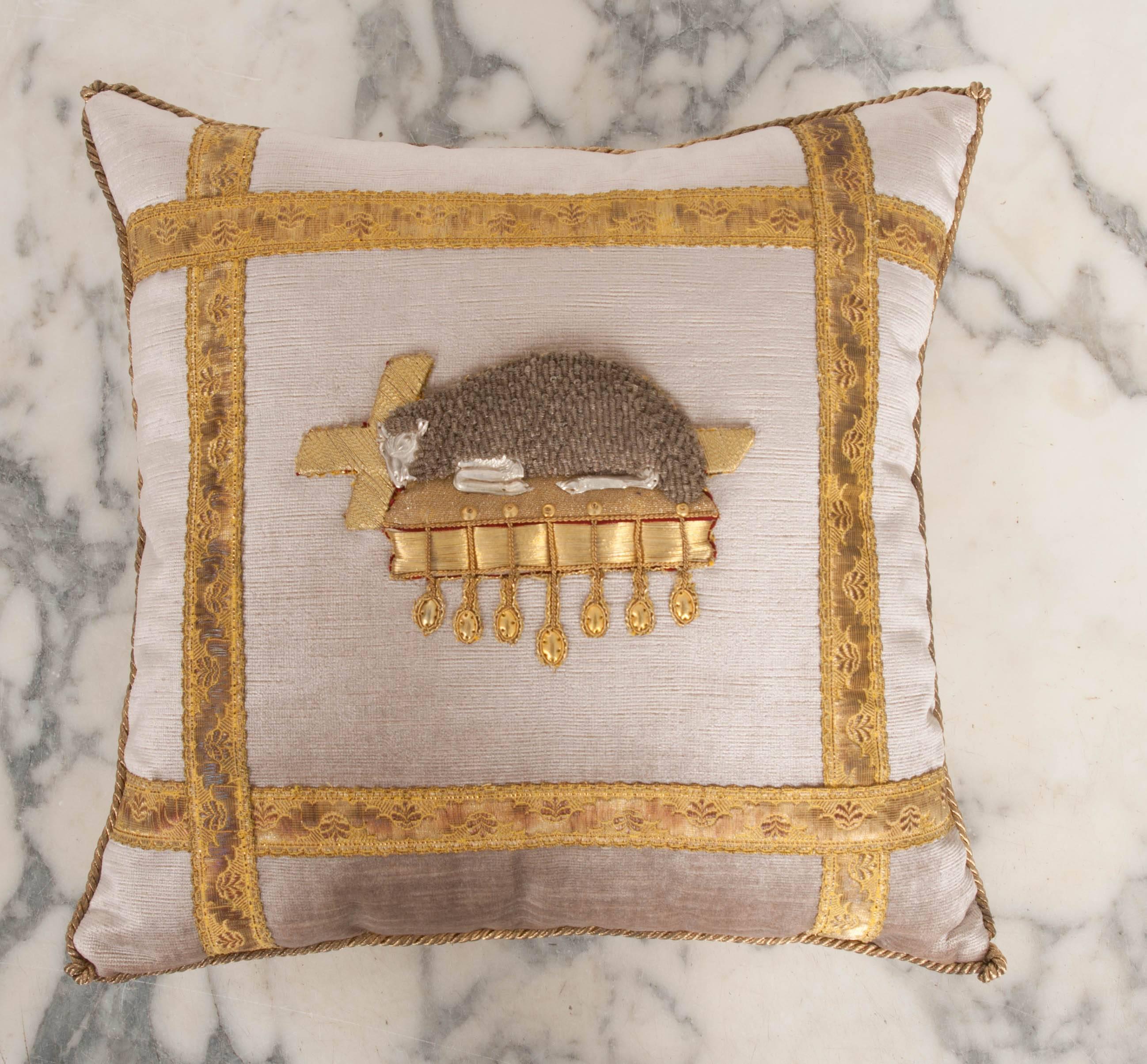 Antique mourning lamb embroidered applique in gold and silver framed with antique gold metallic galon on warm pale taupe velvet. Hand trimmed with vintage gold cording knotted in the corners. Down filled.


 