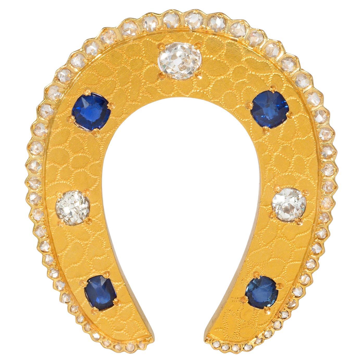 Antique Textured Gold, Sapphire, and Diamond Horseshoe Brooch For Sale