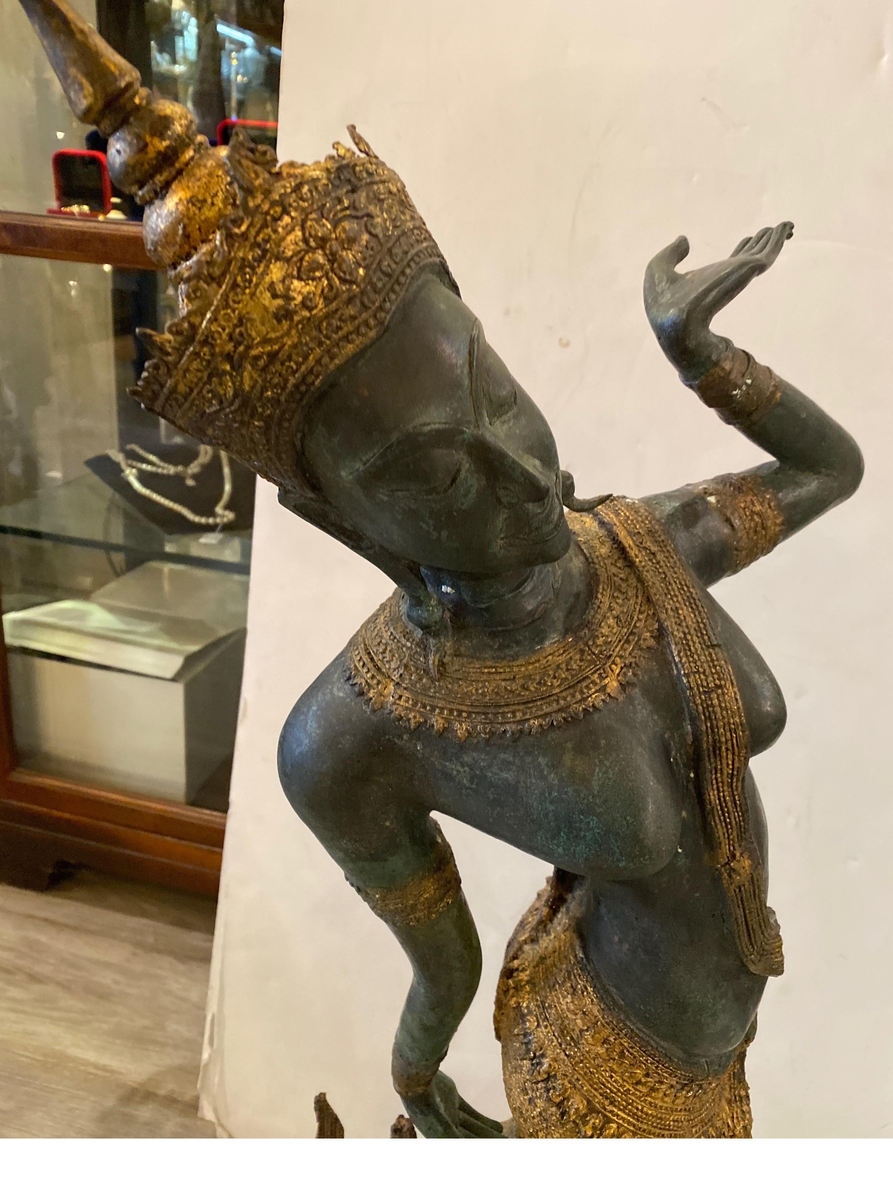 Eine antike Bronzefigur einer thailändischen Tänzerin. Die patinierte und vergoldete Bronzeoberfläche, alles original. In sehr gutem Zustand mit gealtertem Originallack. Die Tänzerin in traditioneller Tracht mit anmutiger Pose. Der rechteckige