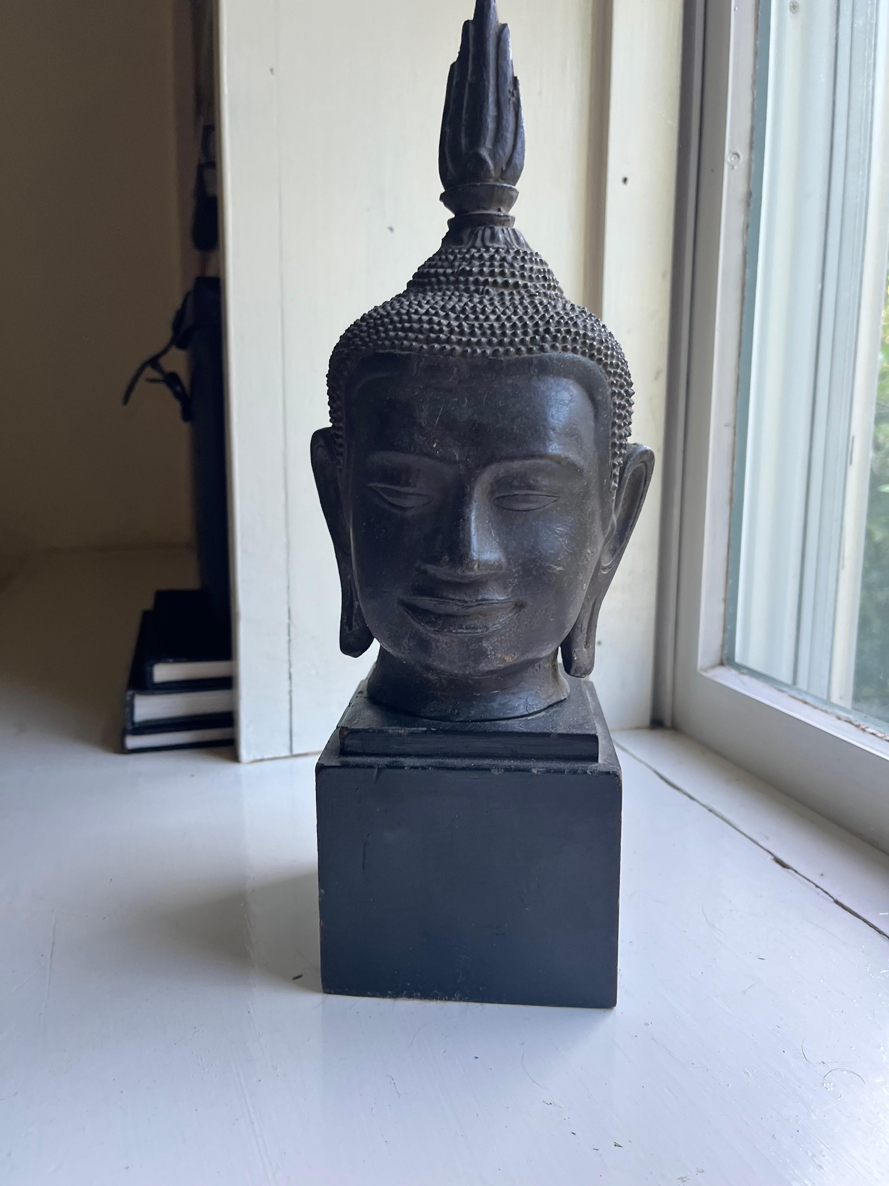 A nicely cast bronze Buddha head from Thailand, 18th century or earlier, now on a custom ebonized wood base. Height of bronze head 10”. 