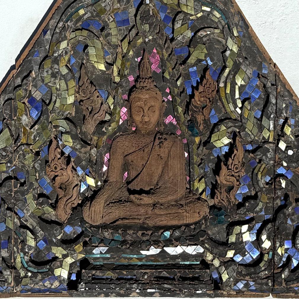 Antique Thai Buddhist Temple Gable Panel. The teak triangular shape featuring a carving of  a seated Buddha on a lotus plinth, depicted with legs crossed in the virasana position with the right leg resting on the left leg, soles up, the hands in the