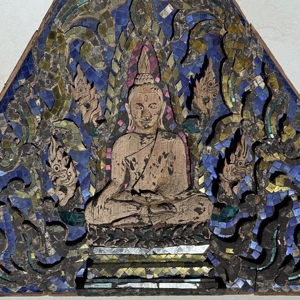Antique Thai Buddhist Temple Gable Panel. The teak triangular shape featuring a carving of a seated Buddha on a lotus style plinth, depicted with legs crossed in the virasana position with the right leg resting on the left leg, soles up, the hands