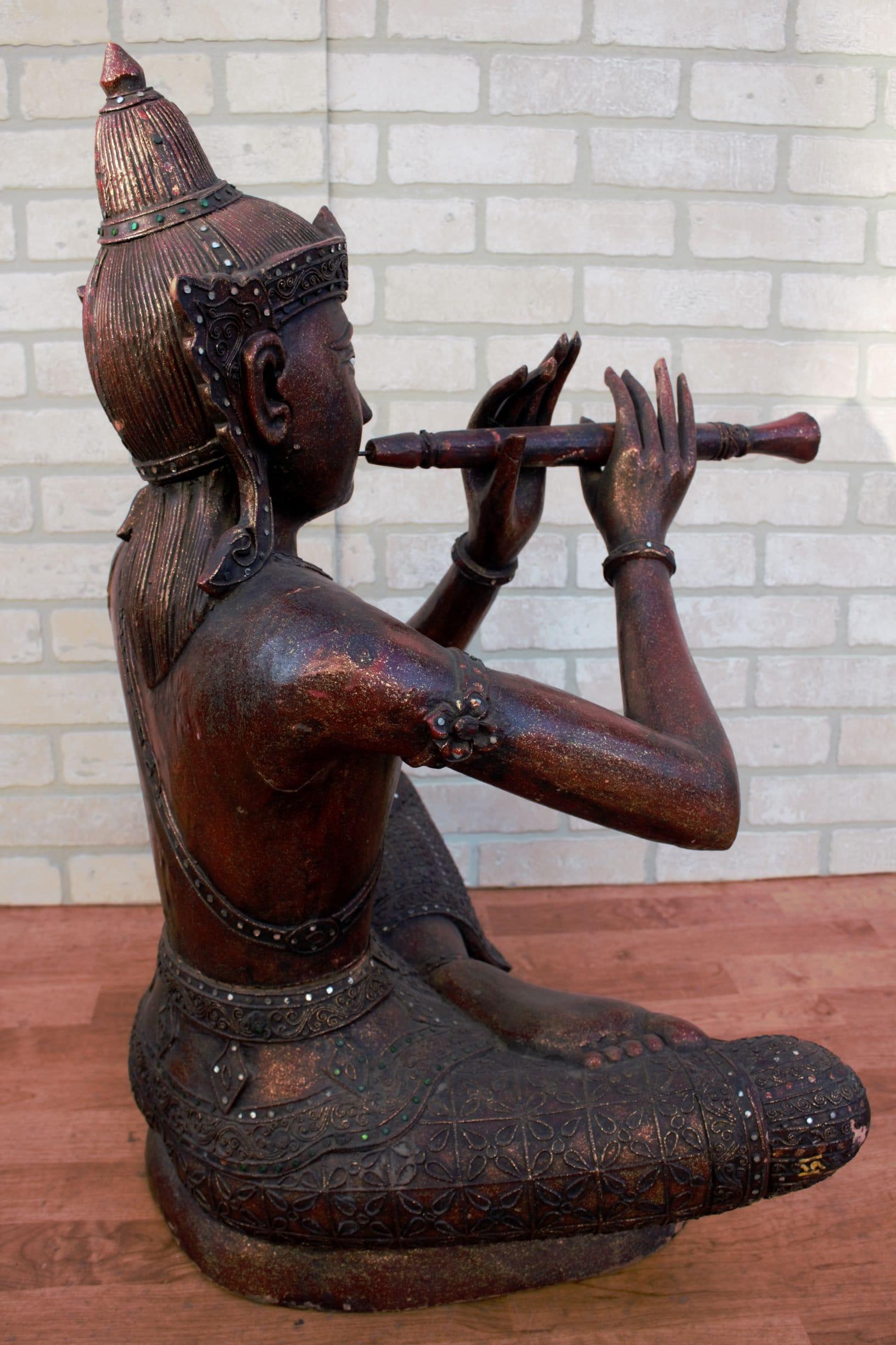 Mid-20th Century Antique Thai Carved Seated Buddha Playing a Flute For Sale