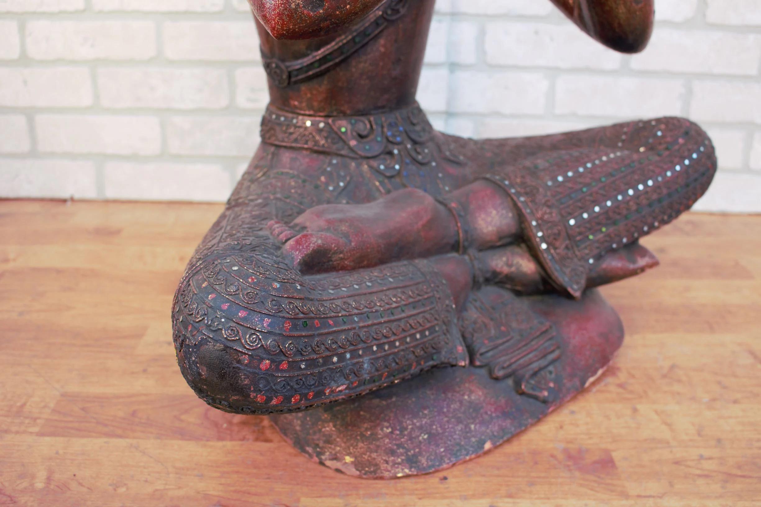 Antiker thailändischer geschnitzter sitzender Buddha, der eine Flöte spielt (Spiegel) im Angebot